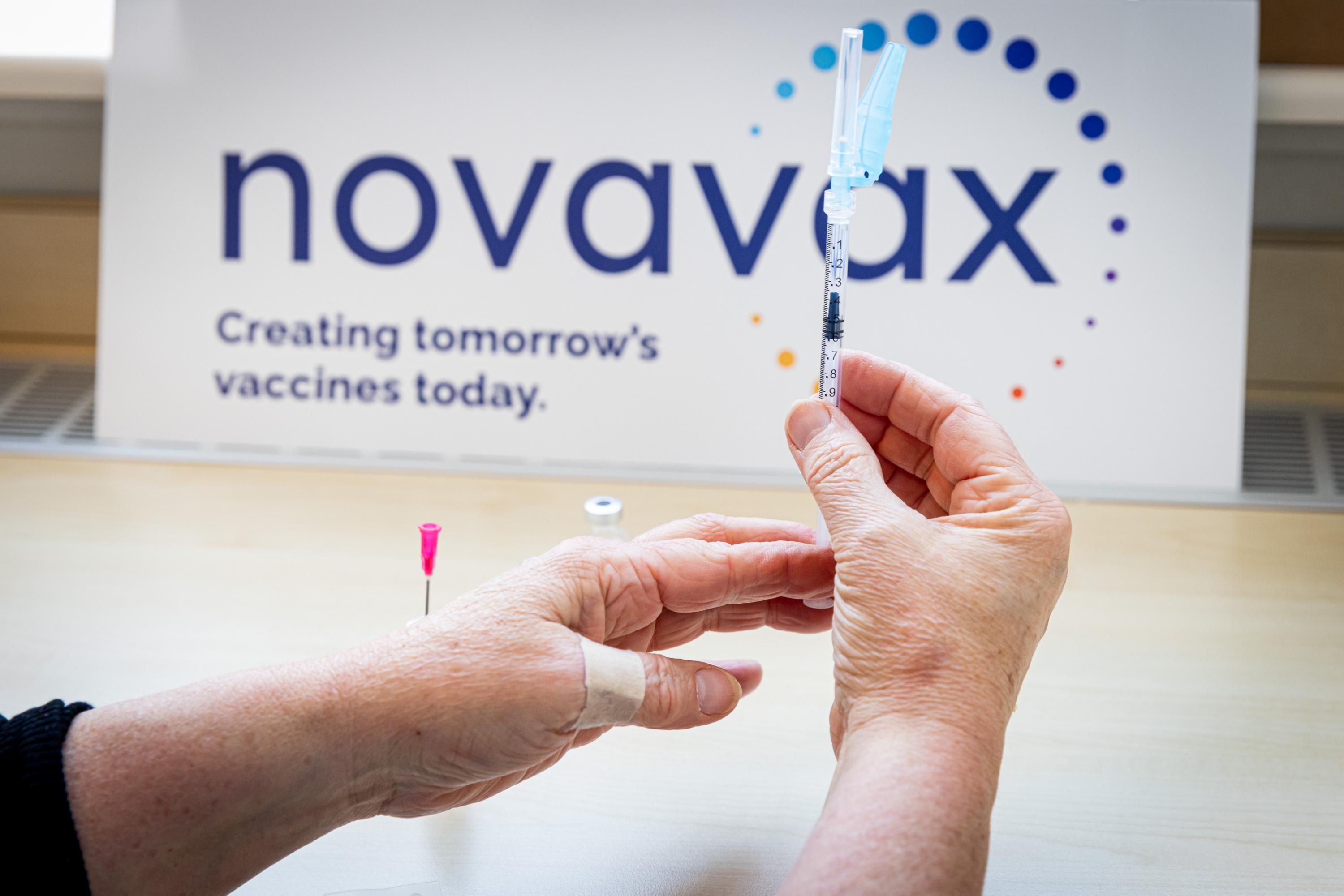 A health worker holds a Novavax vaccine
