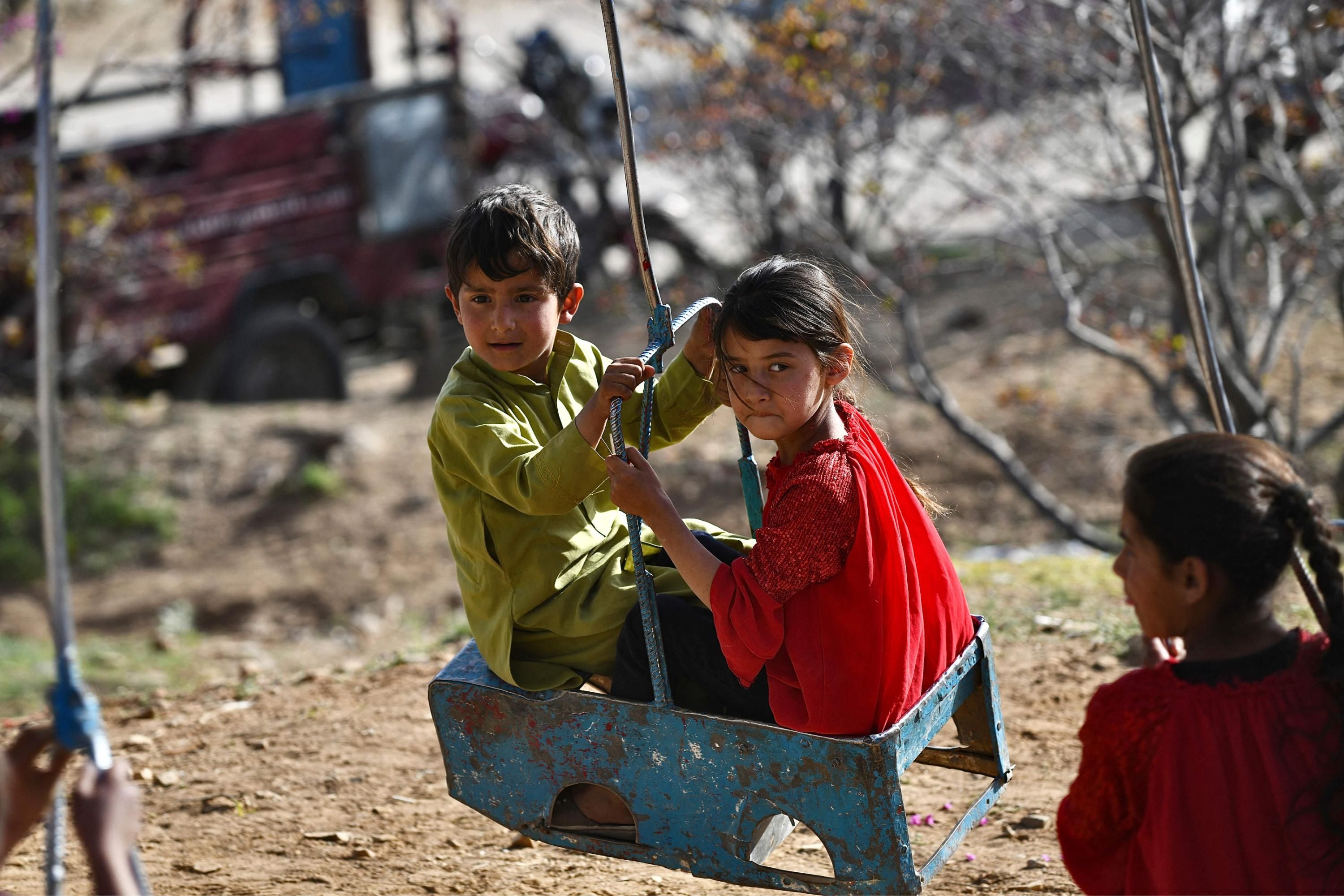 Afghan children ride on a swing