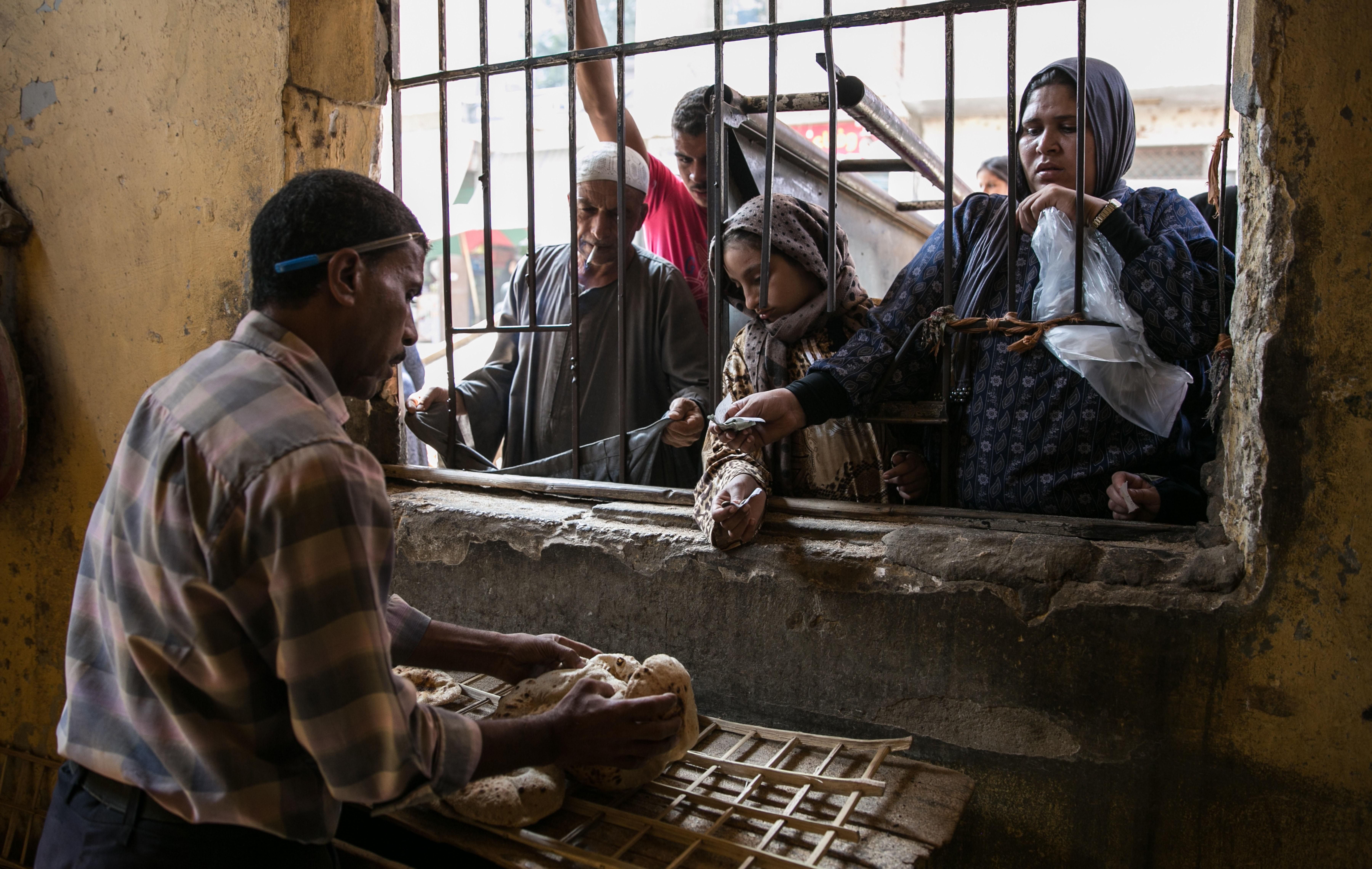 Egyptian women are seen as they buy bread from a bakery in Cairo, Egypt on September 23, 2014.