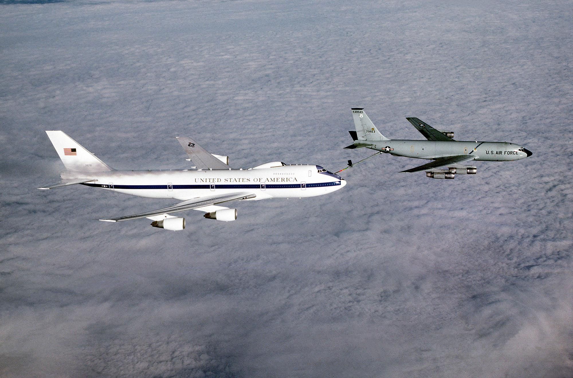 An air-to-air right side view of an E-4B advanced airborne national command post aircraft being refueled from a KC-135 Stratotanker aircraft.