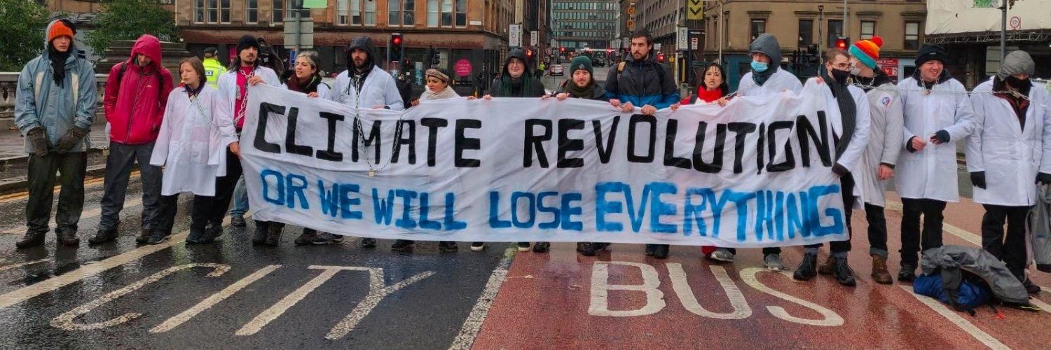 Scientists hold sign calling for a climate revolution