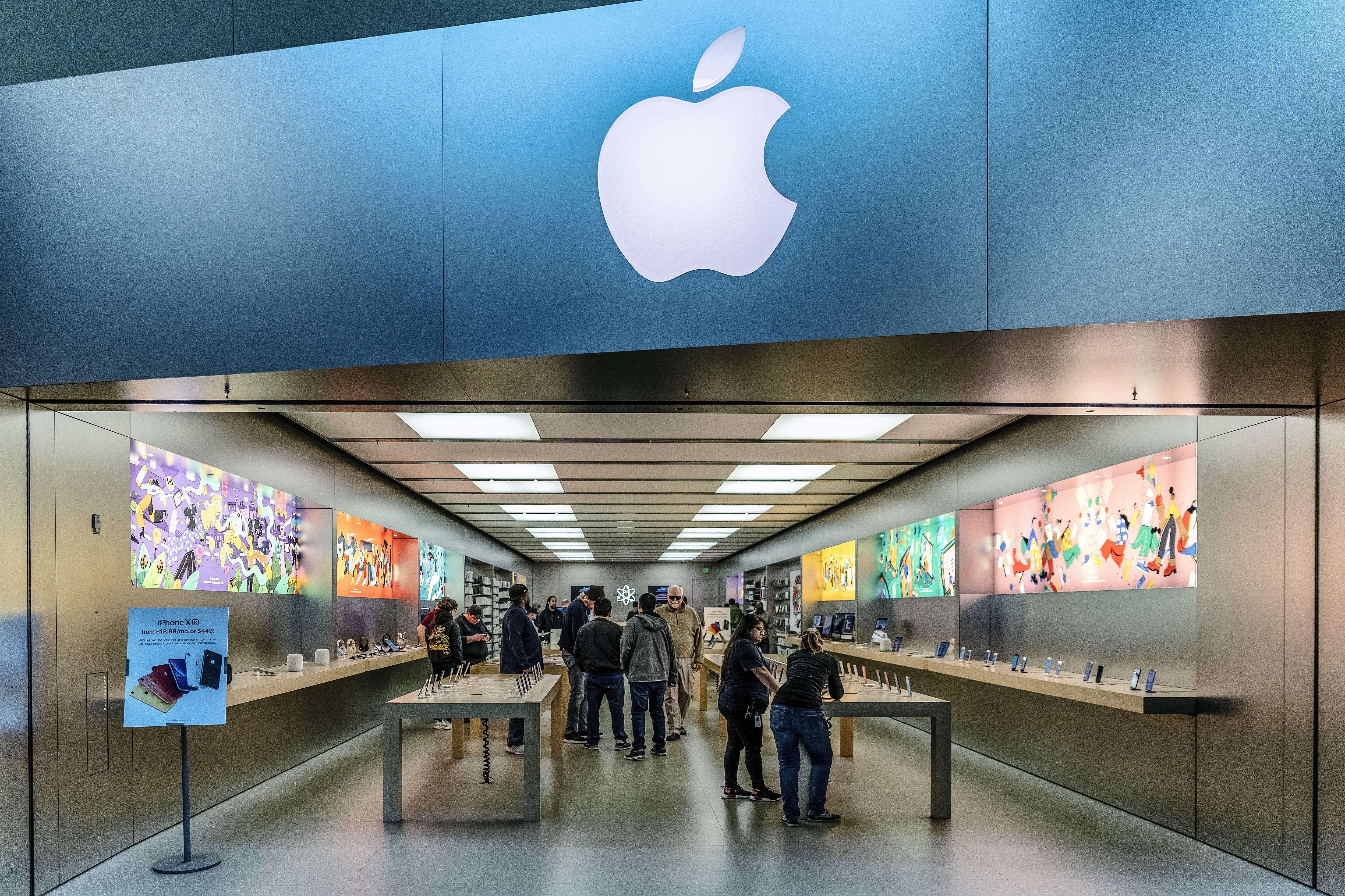 People walk through an Apple retail store in Buford, Georgia on March 28, 2019. 
