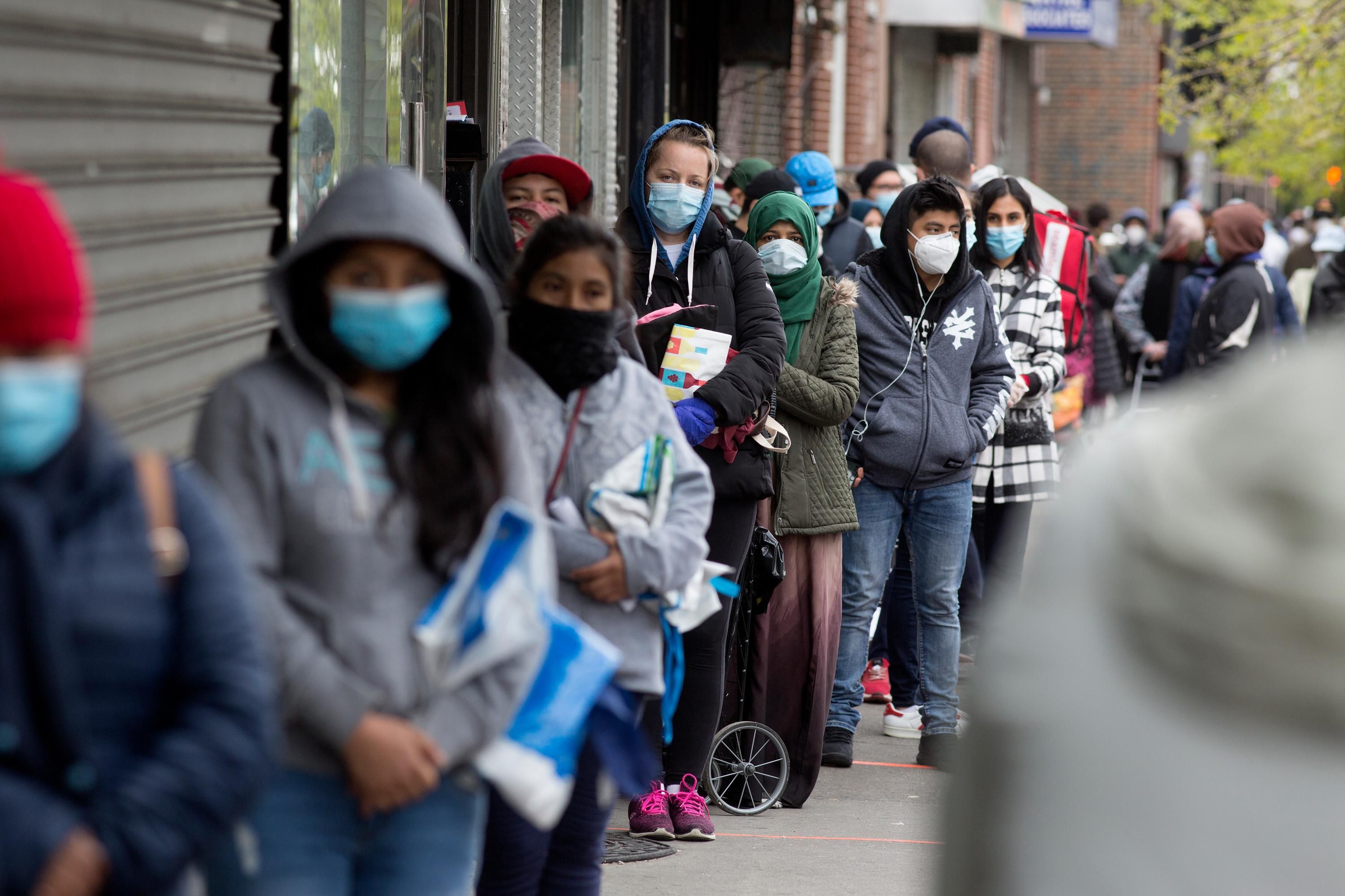 People line up to receive food from a food pantry