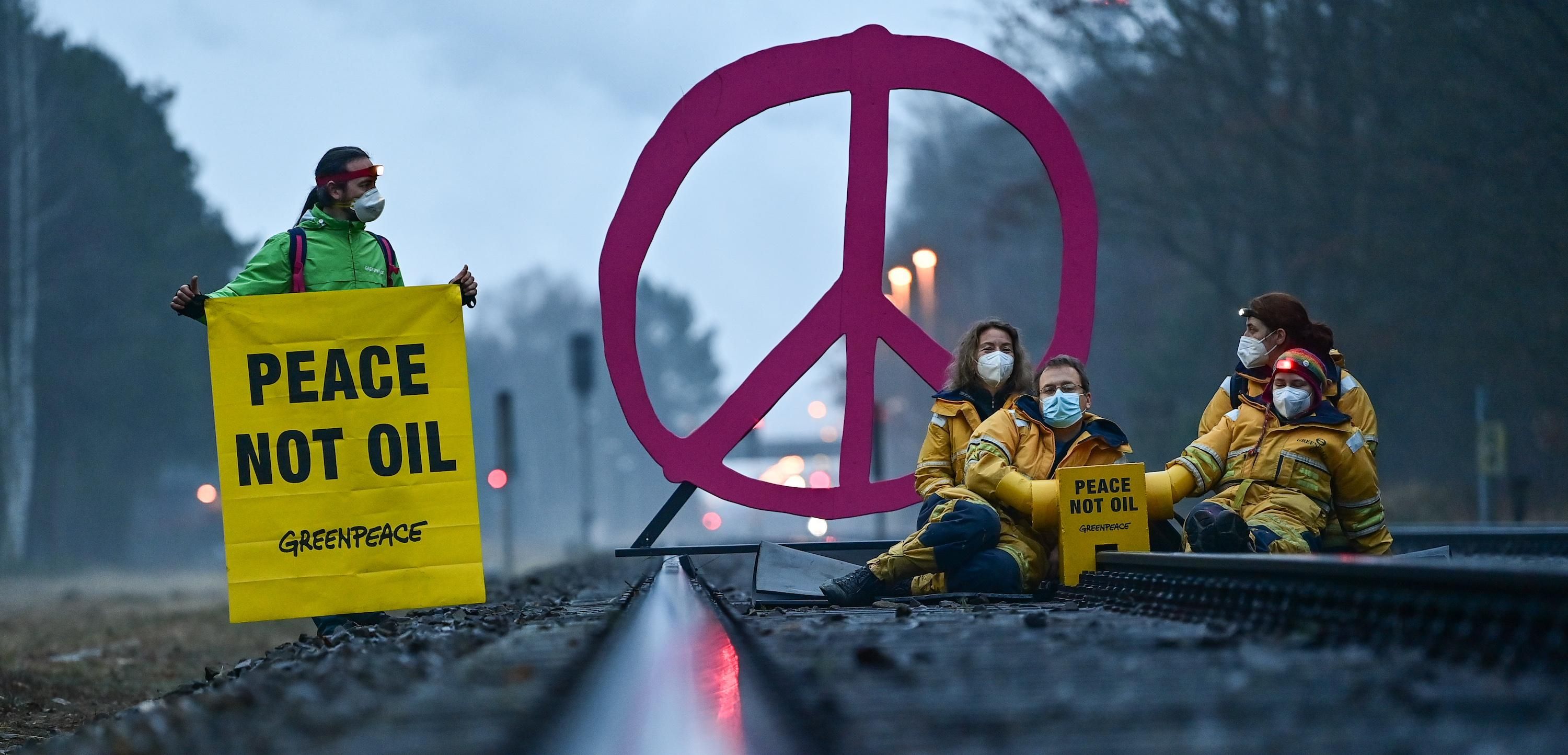 Activists from Greenpeace block a rail track leading to the oil refinery of PCK-Raffinerie GmbH in Germany on March 15, 2022 to protest against fossil imports from Russia and the indirect financing of the war in Ukraine. (Photo: Patrick Pleul/dpa-Zentralbild/ZB via Getty Images)