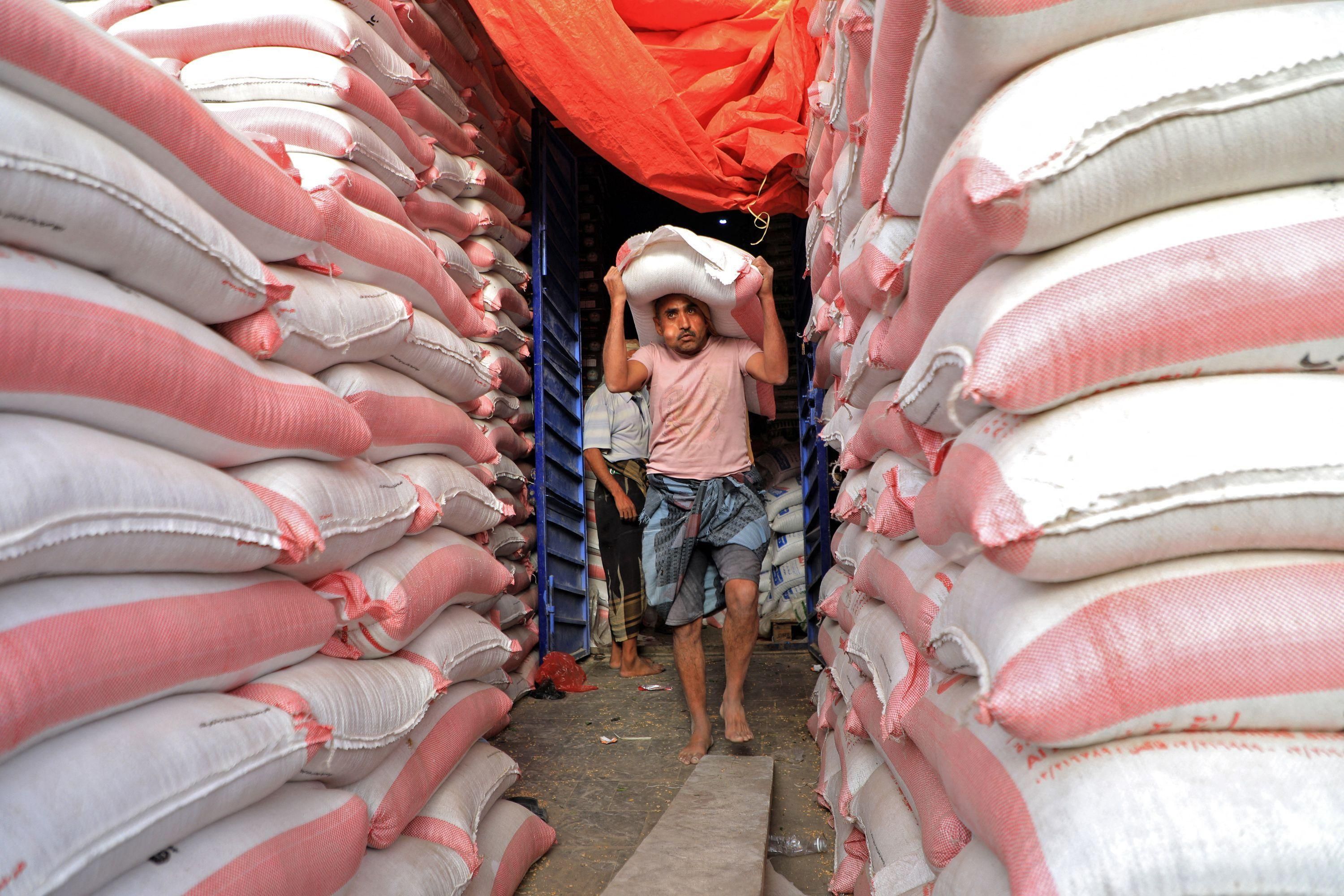 Yemeni workers carry bags of flour at a bakery in the capital Sanaa, on March 27, 2022. With the country almost completely dependent on imports, aid groups say the situation will only worsen following Russia's invasion of Ukraine, which produces nearly a third of Yemen's wheat supplies. (Photo: Mohammed Huwais/AFP via Getty Images)