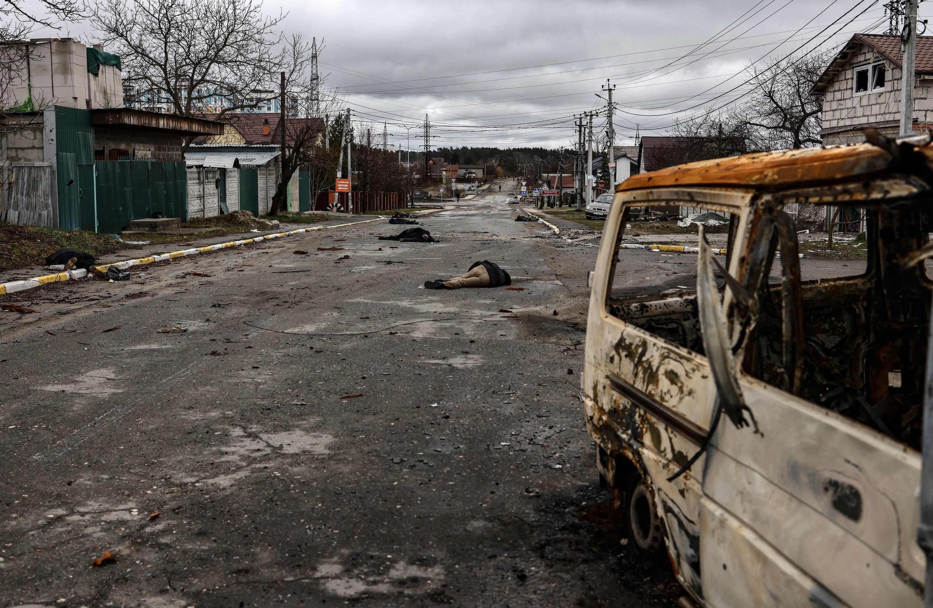 Bodies lie on a street in Bucha, northwest of Kyiv, on April 2, 2022, as Ukraine says Russian forces are making a "rapid retreat" from northern areas around Kyiv and the city of Chernigiv. 