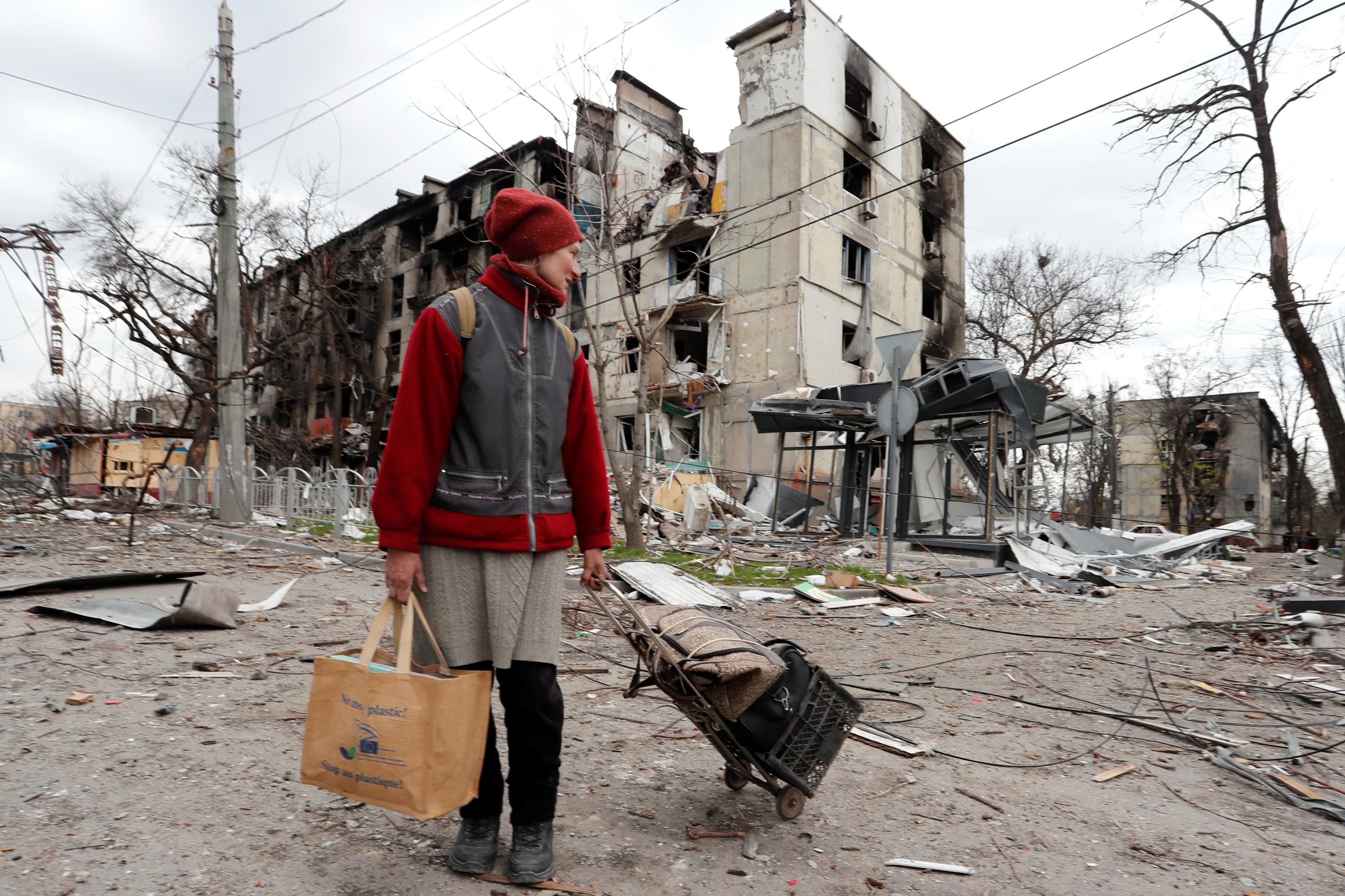 A Mariupol resident walks amid the city's ruins