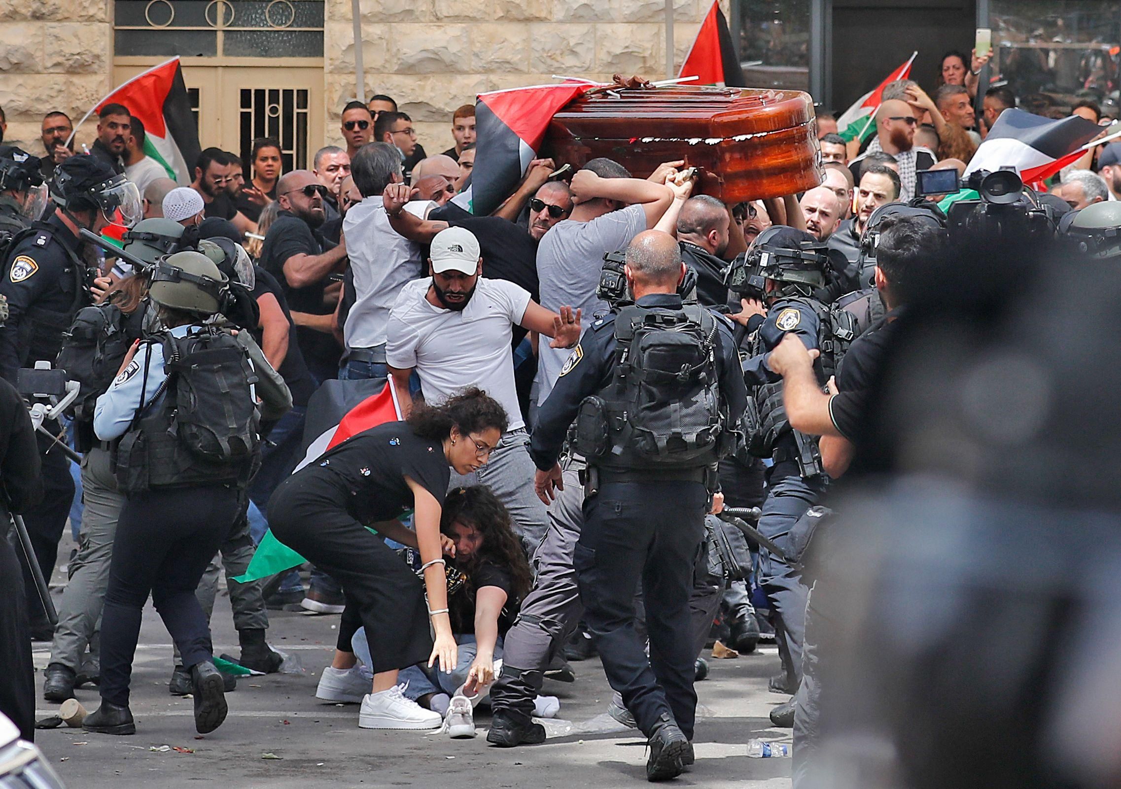 Israeli forces beat Palestinian mourners carrying the casket of slain Al Jazeera journalist Shireen Abu Akleh from a hospital in Jerusalem to her final resting place on May 13, 2022. 