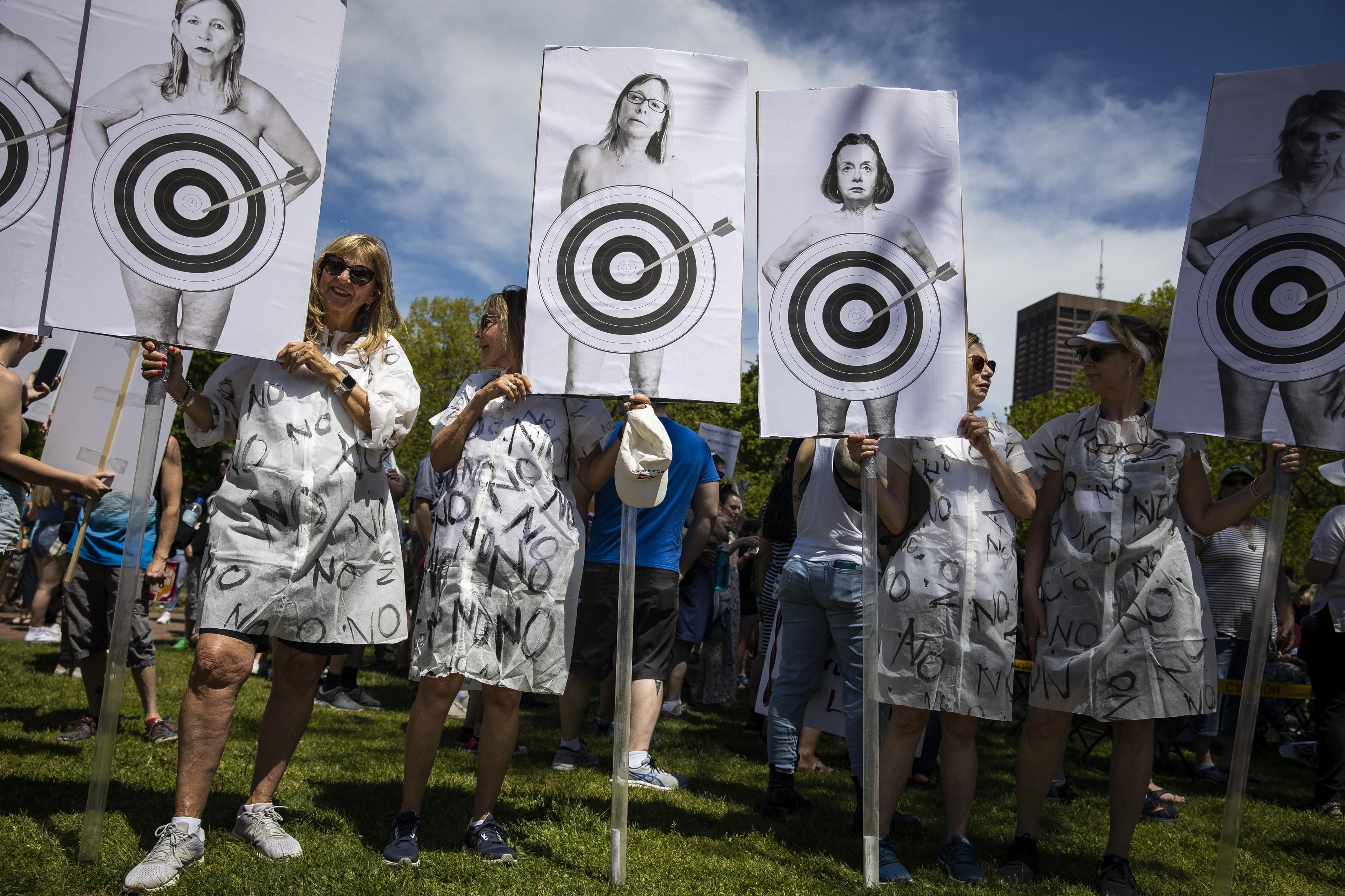 Pro-choice demonstrators with posters showing bullseyes on women's bodies