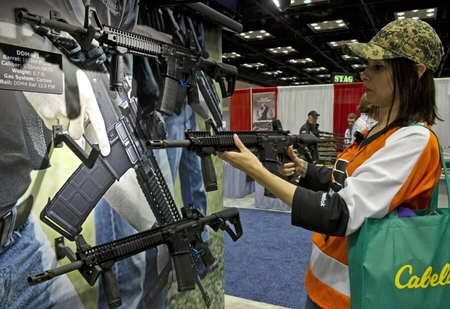 A person examines a gun at an NRA meeting
