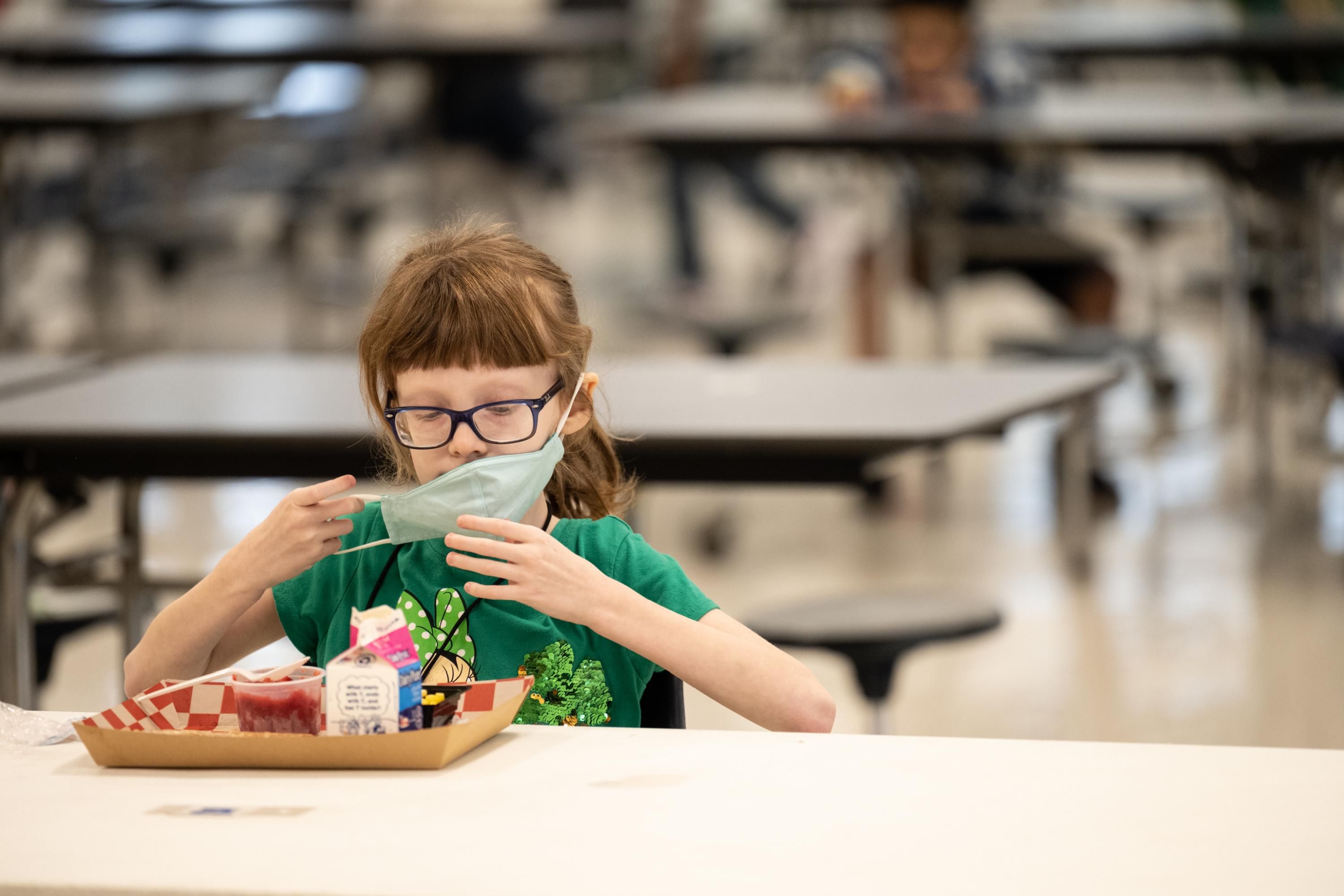 An elementary school student finishes a meal