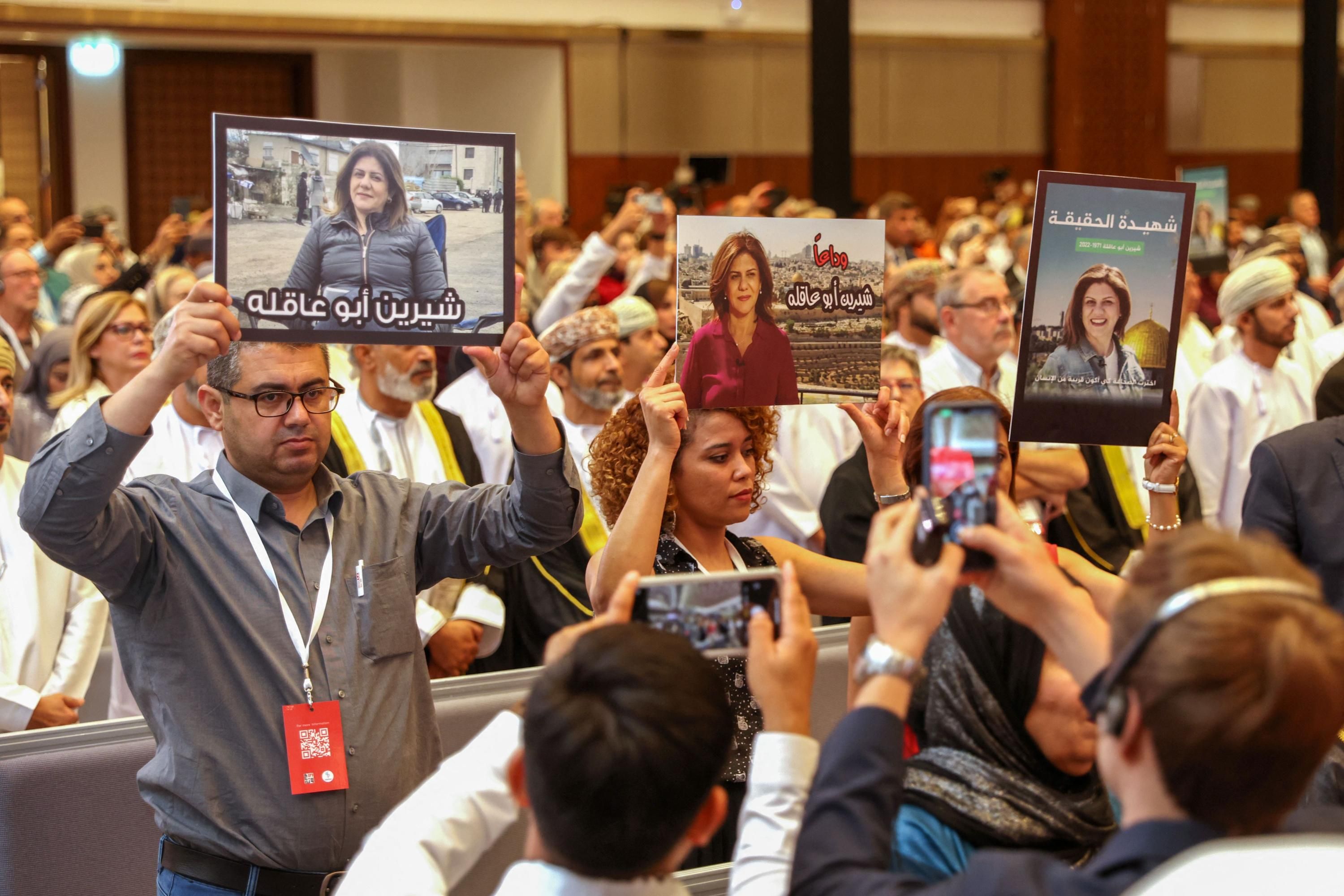 Journalists hold posters displaying Shireen Abu Akleh