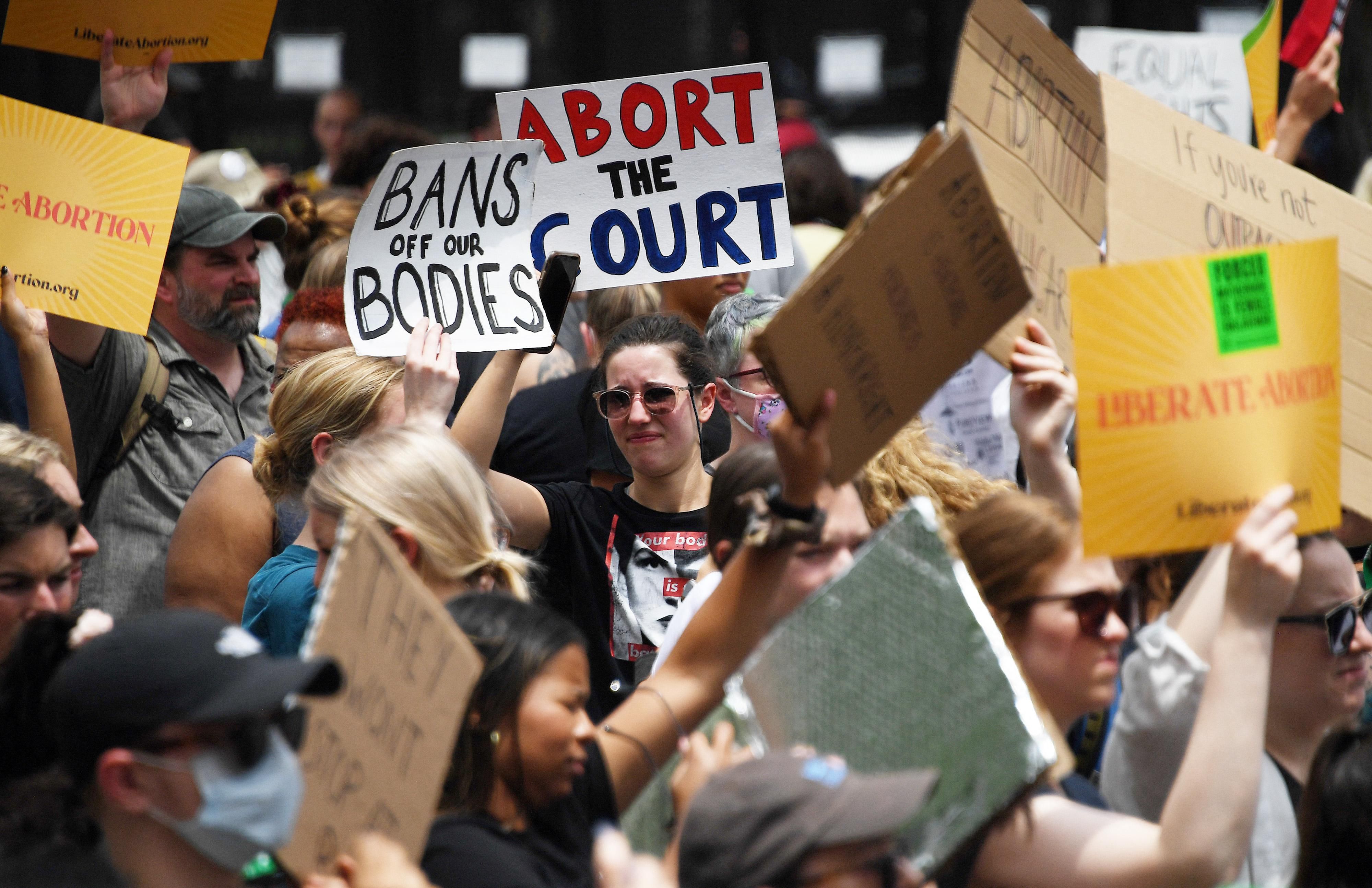 Abortion rights activists hoist their signs outside the U.S. Supreme Court in Washington, D.C. on June 24, 2022.