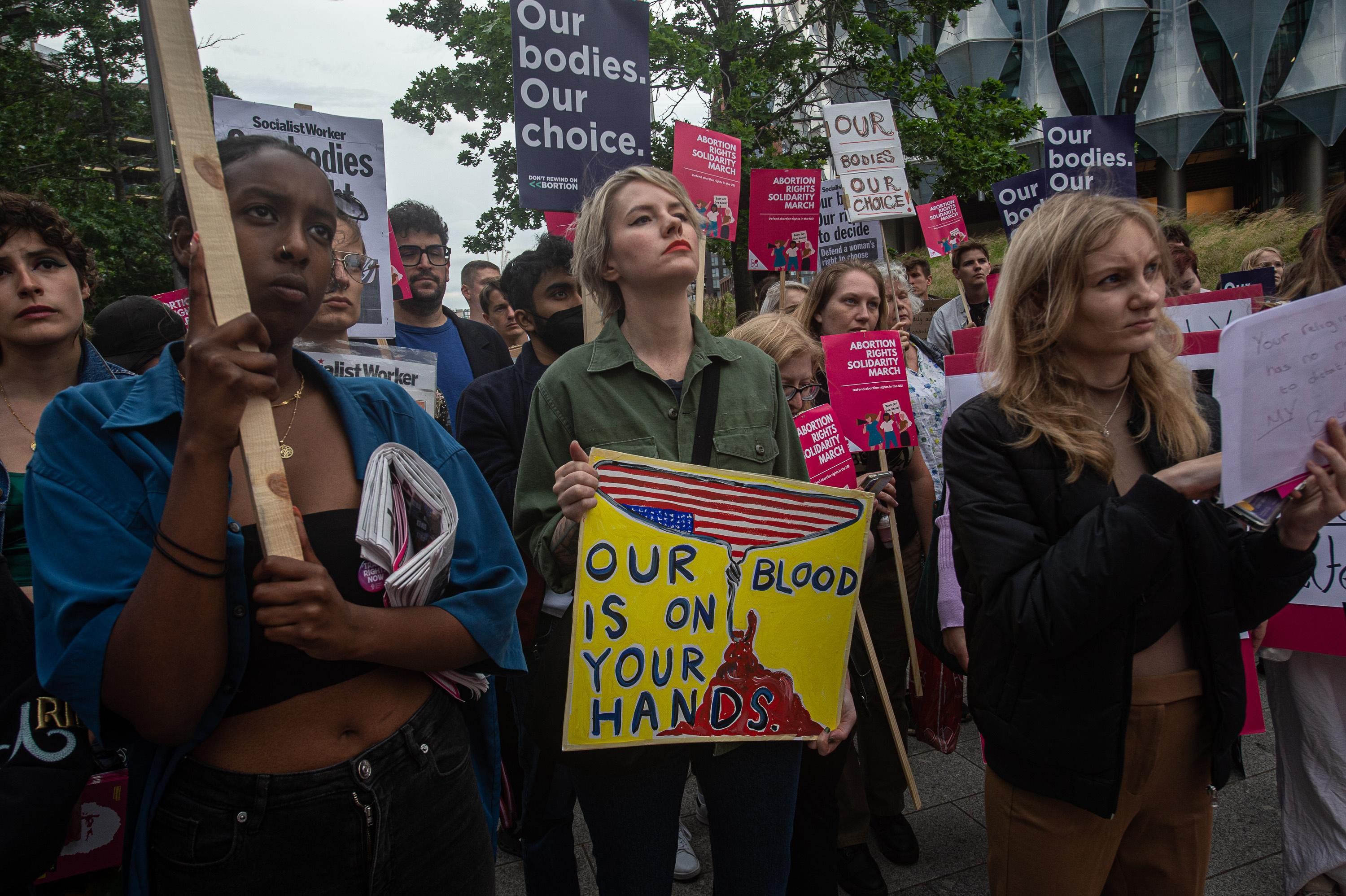 Demonstrators hold signs during an abortion rights protest in London
