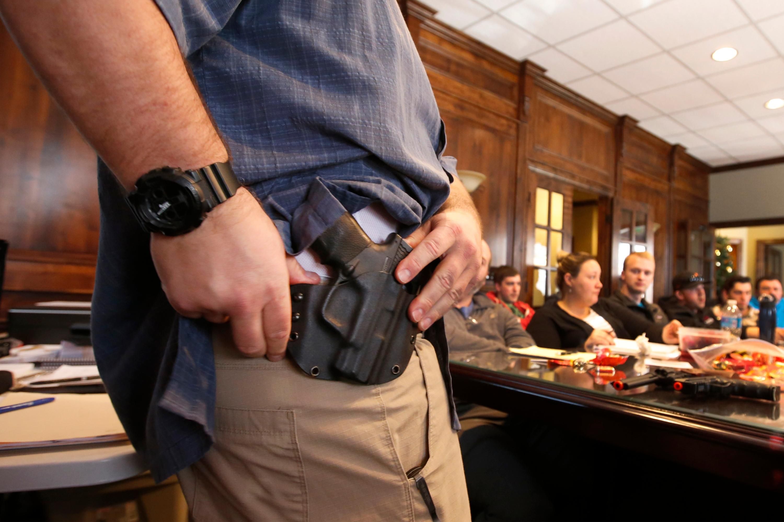A man shows a gun holdster