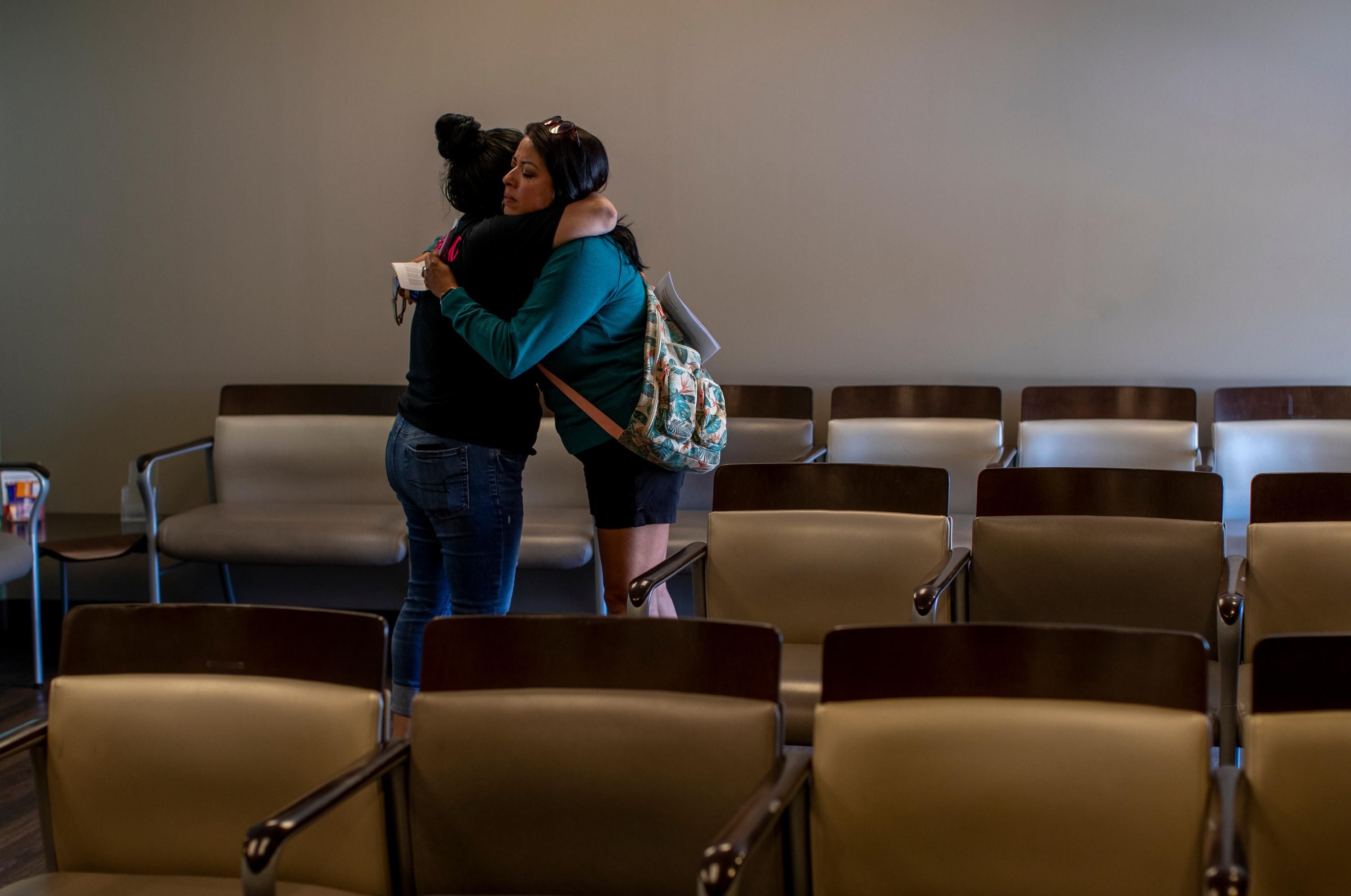 Clinic worker embraces patient 