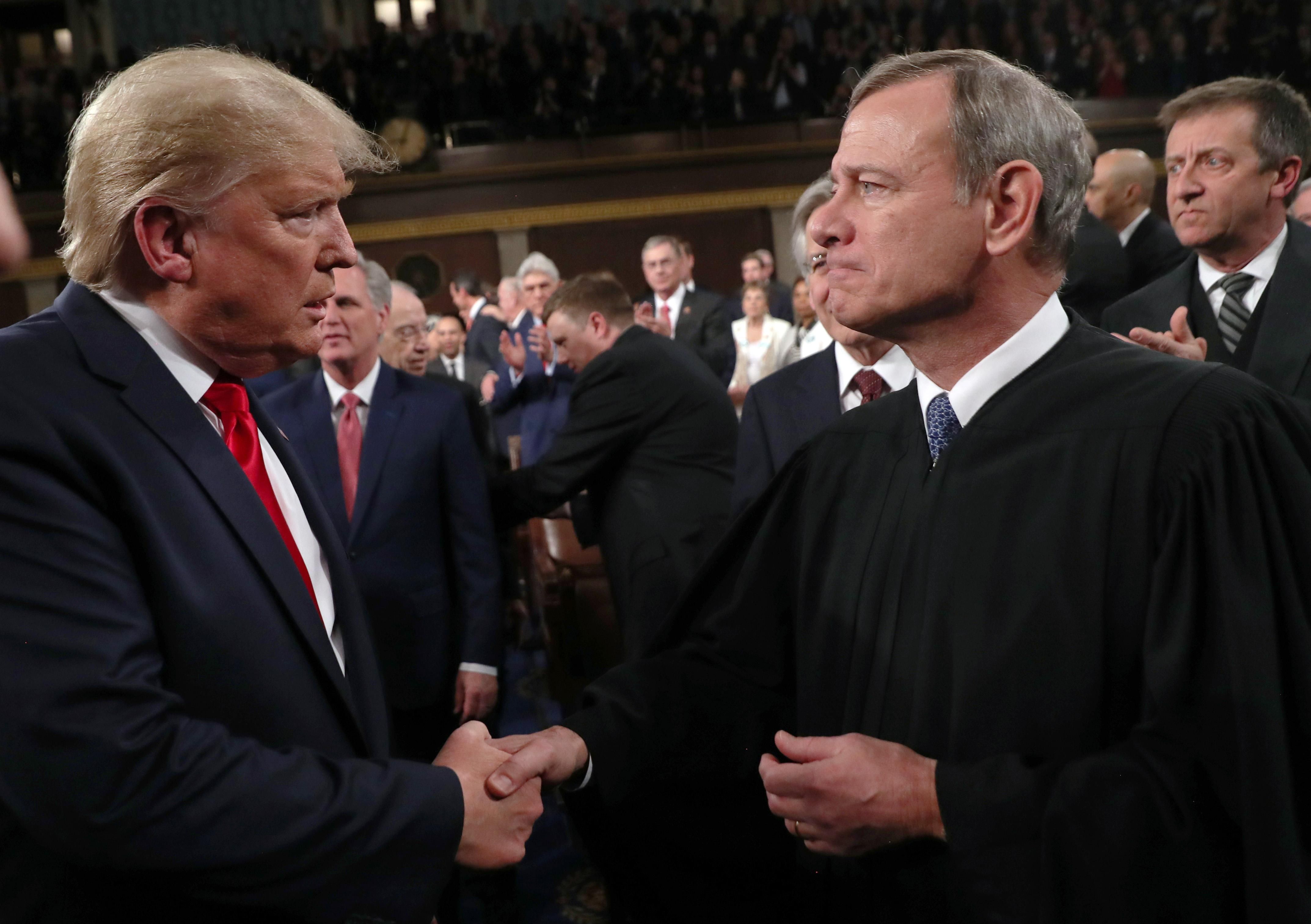Chief Justice John Roberts shaking hands with former President Donald Trump