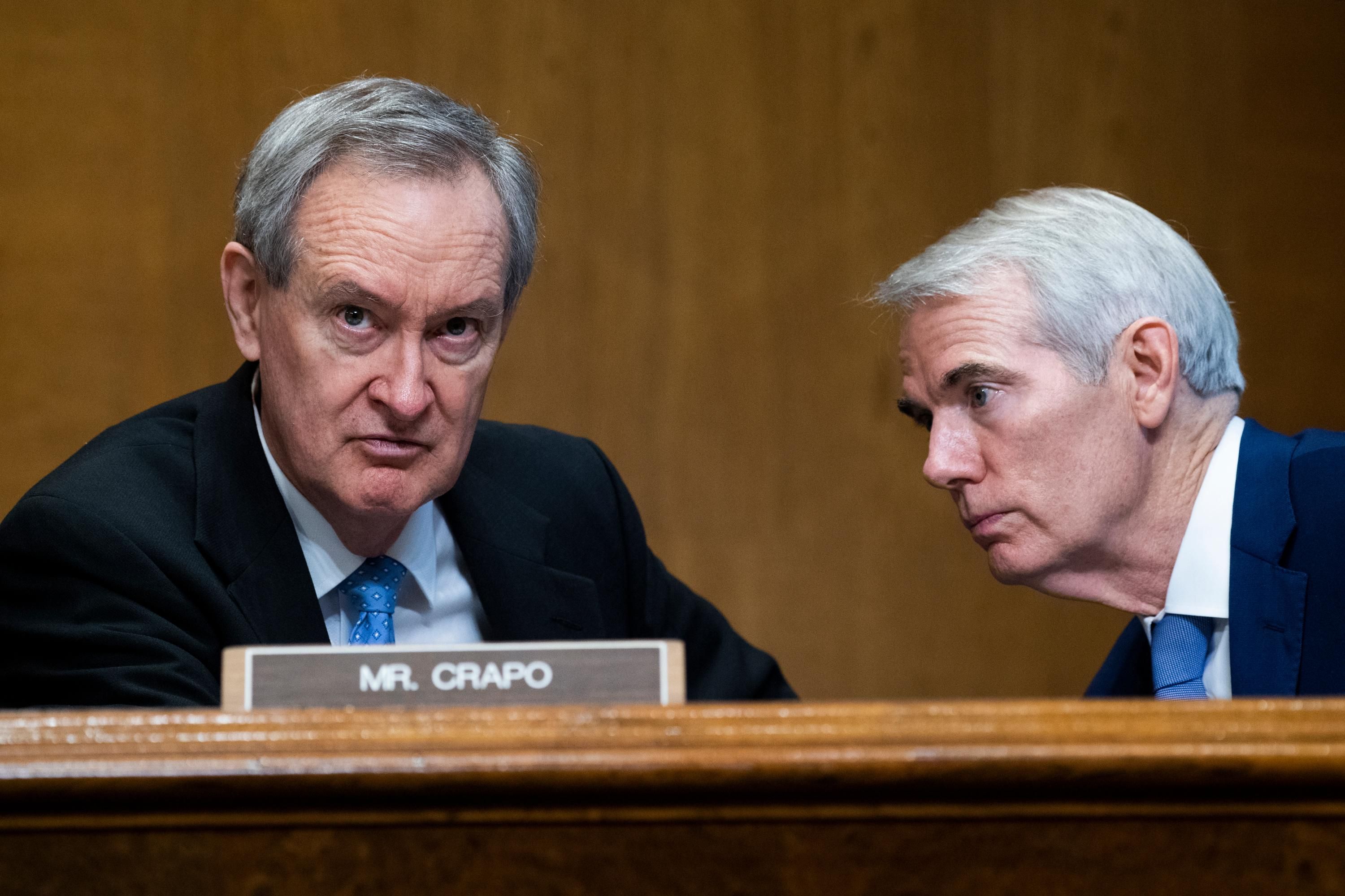 Sen. Mike Crapo speaks to Sen. Rob Portman during a hearing