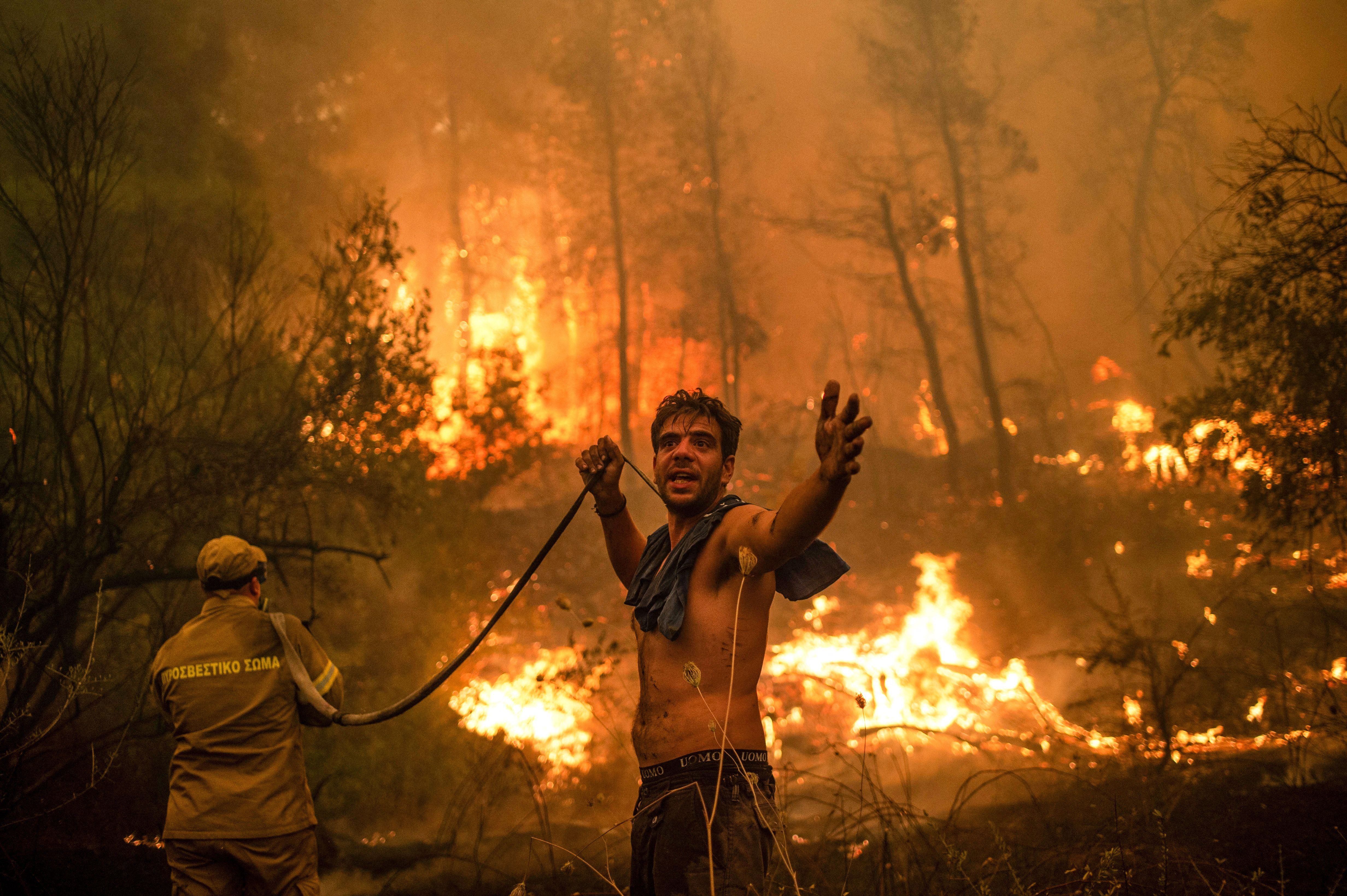 A man trying to put out a wildfire in Greece