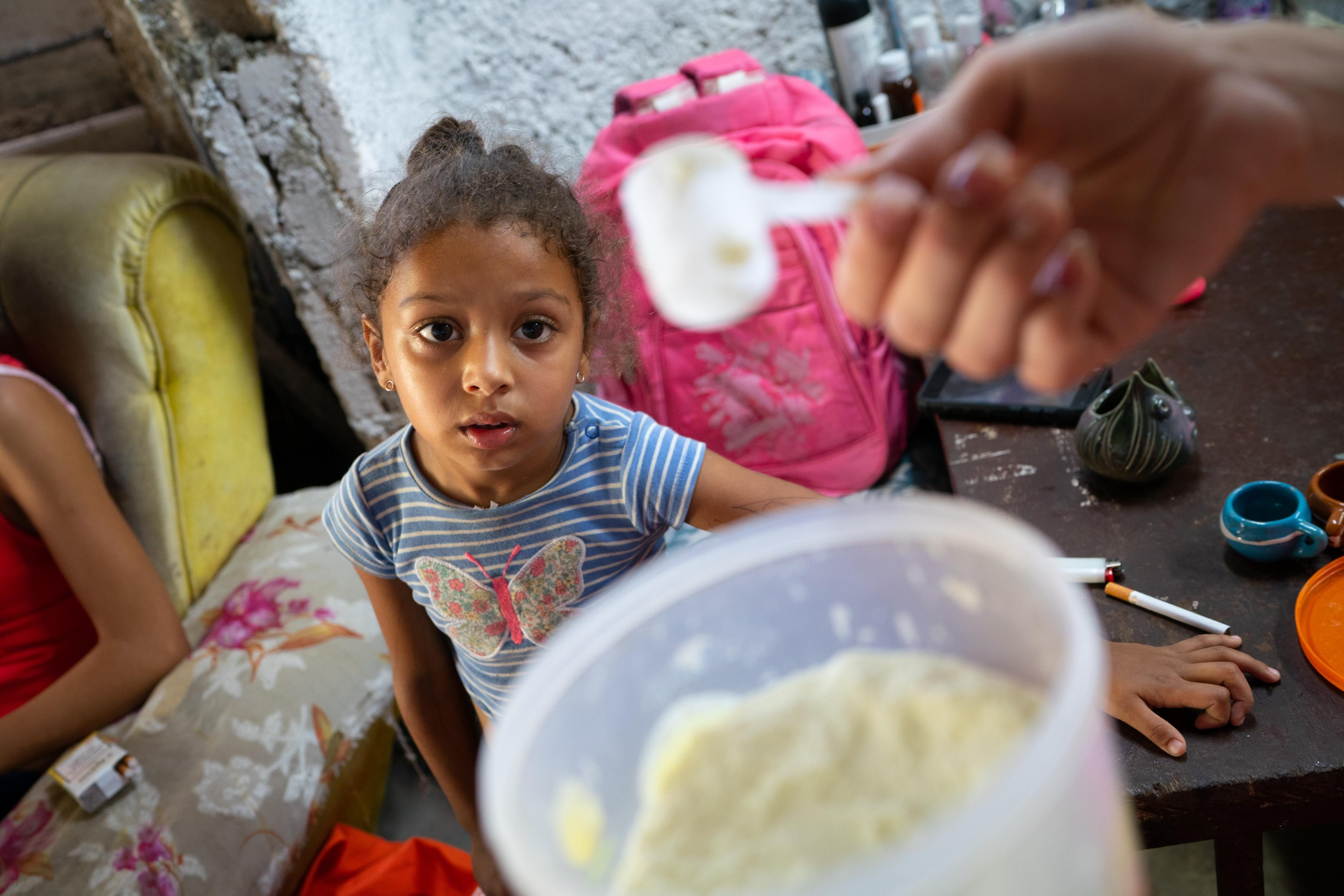 Laurent Alemany, 4, looks at the small amount of powdered milk her mother, Yohana Perdomo, 28, has left in their home in Havana, Cuba on April 16, 2022. 