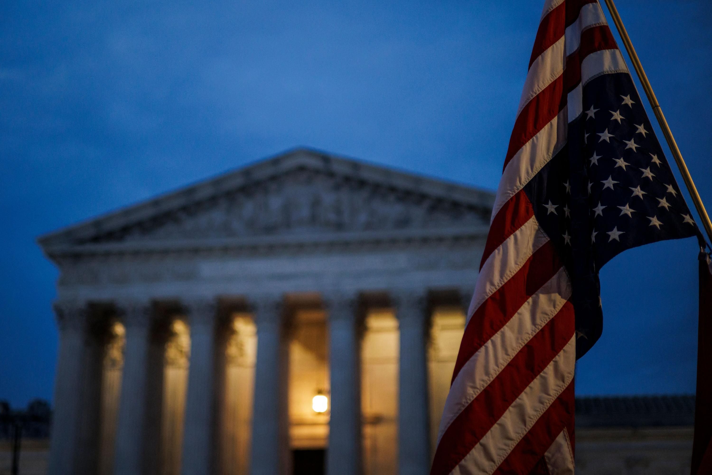 An abortion rights protester flies an upside-down U.S. flag