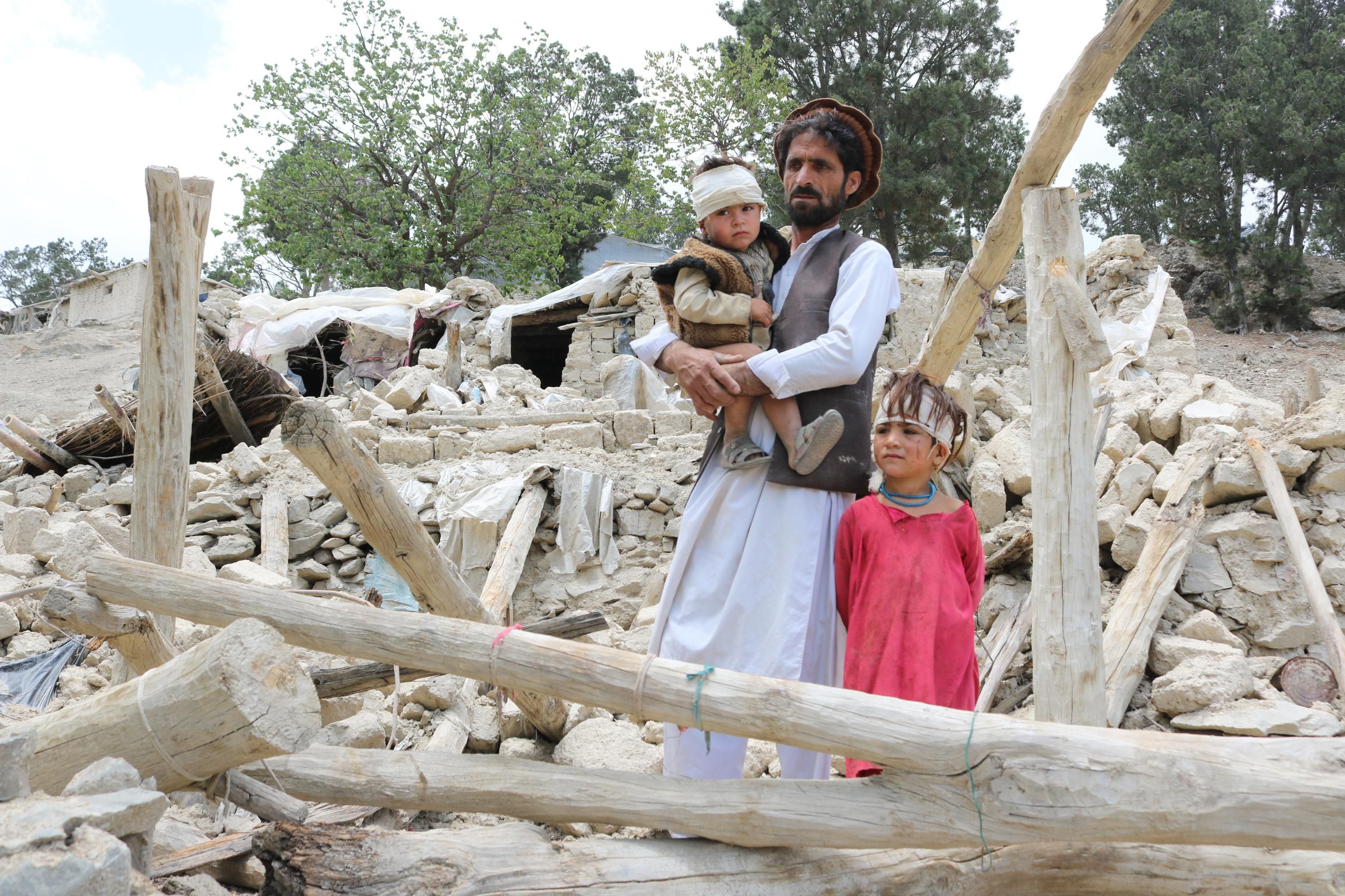 Afghans who lost family membrers in a recent earthquake examine the ruins