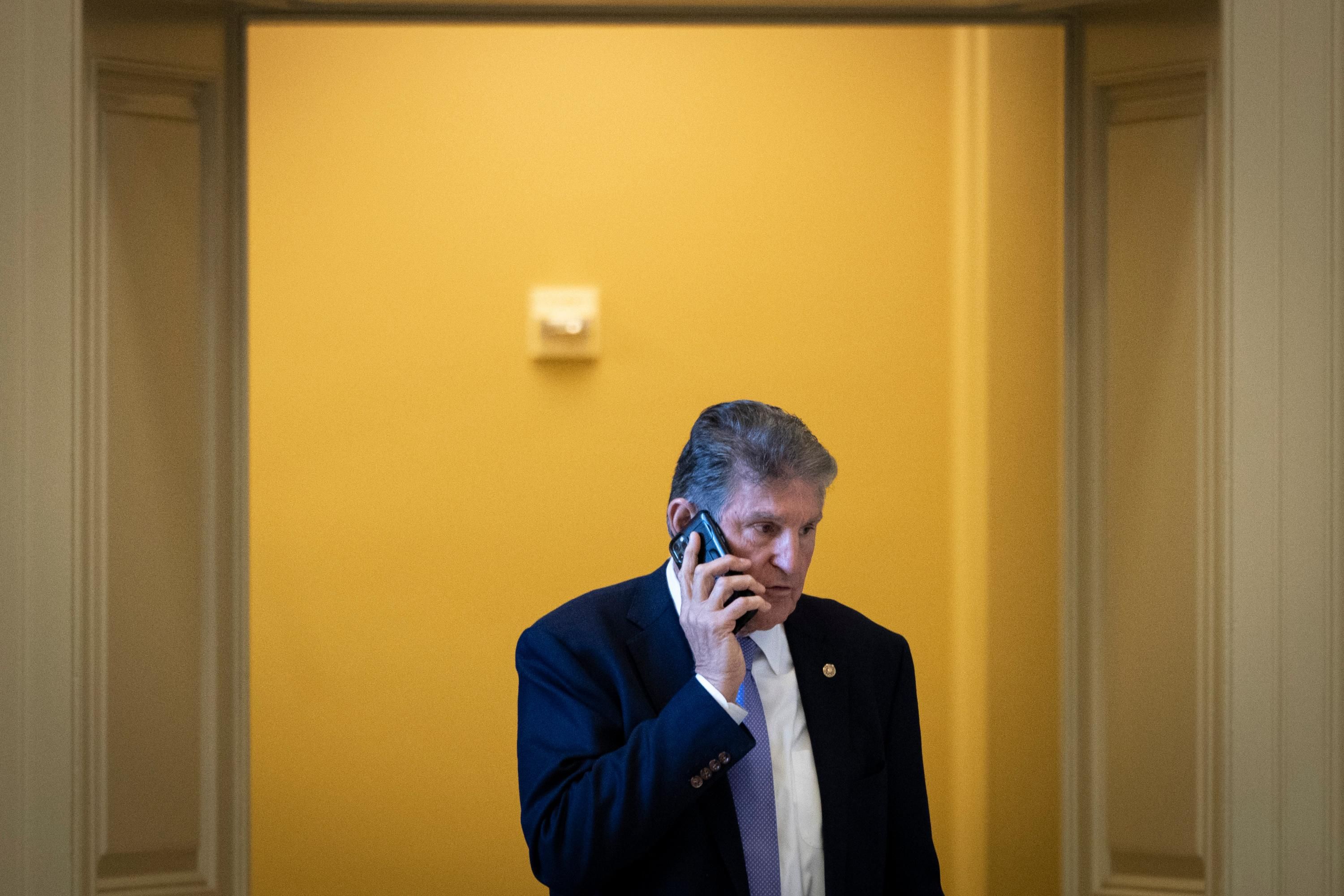 Sen. Joe Manchin speaks on the phone on Capitol Hill
