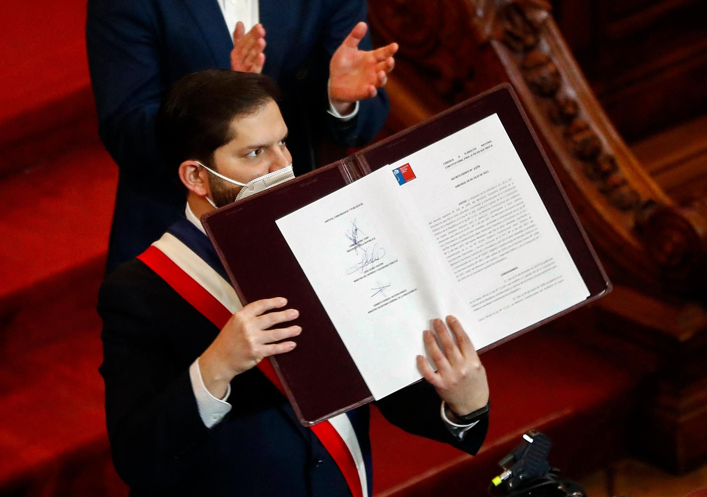 Chile's President Gabriel Boric holds the country's draft Constitution
