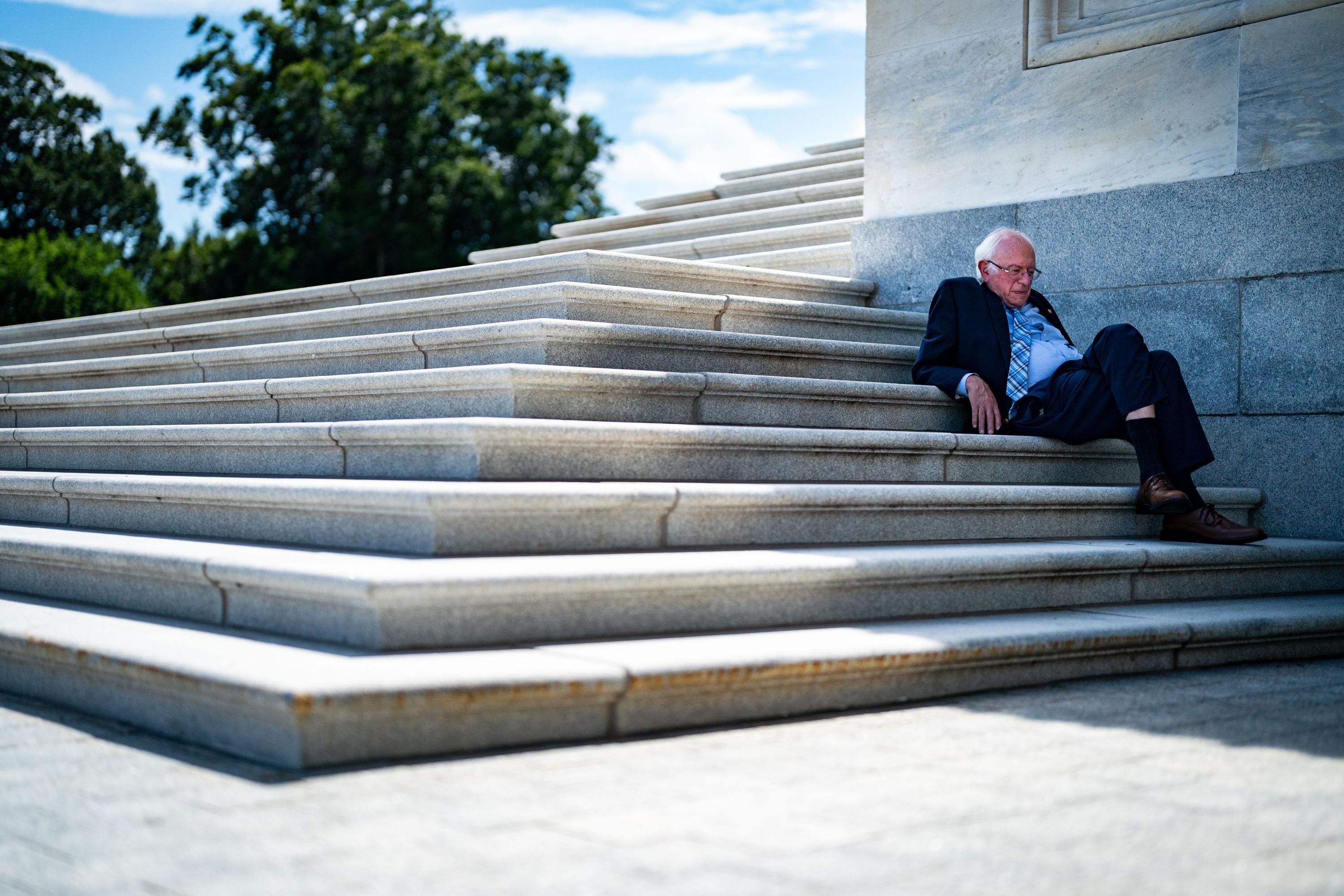 Sen. Bernie Sanders sits on the steps of the U.S. Senate