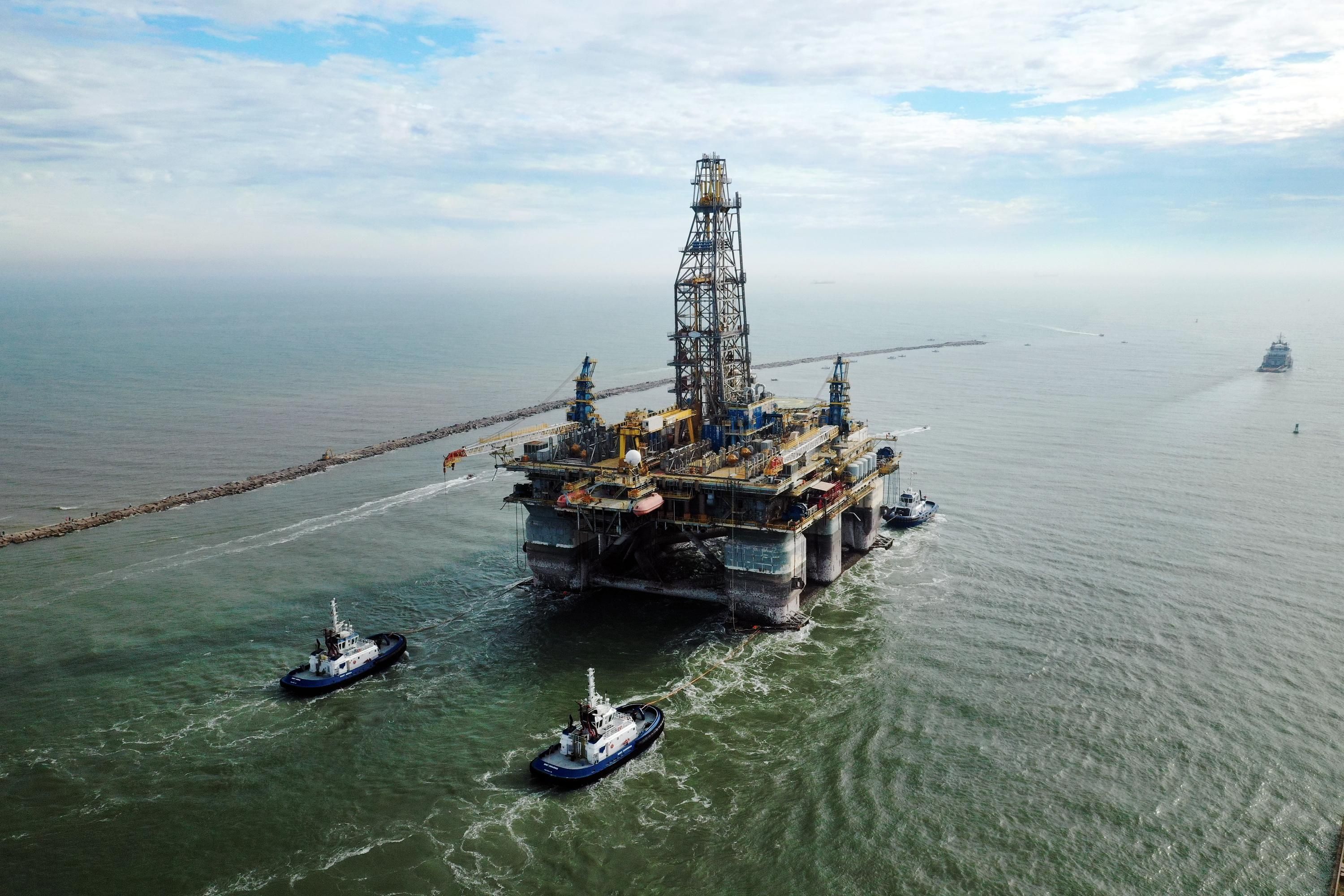 Tug boats tow a drilling platform