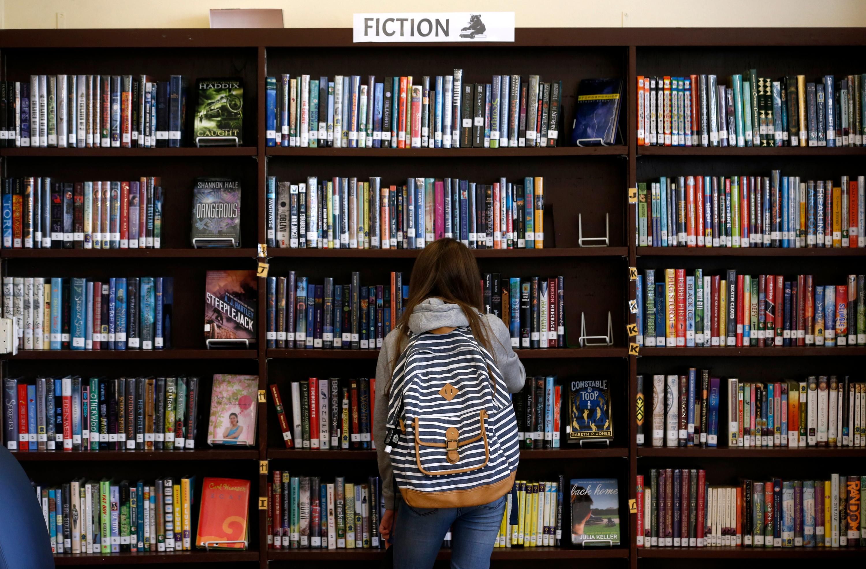 A girl browsing a library shelf.