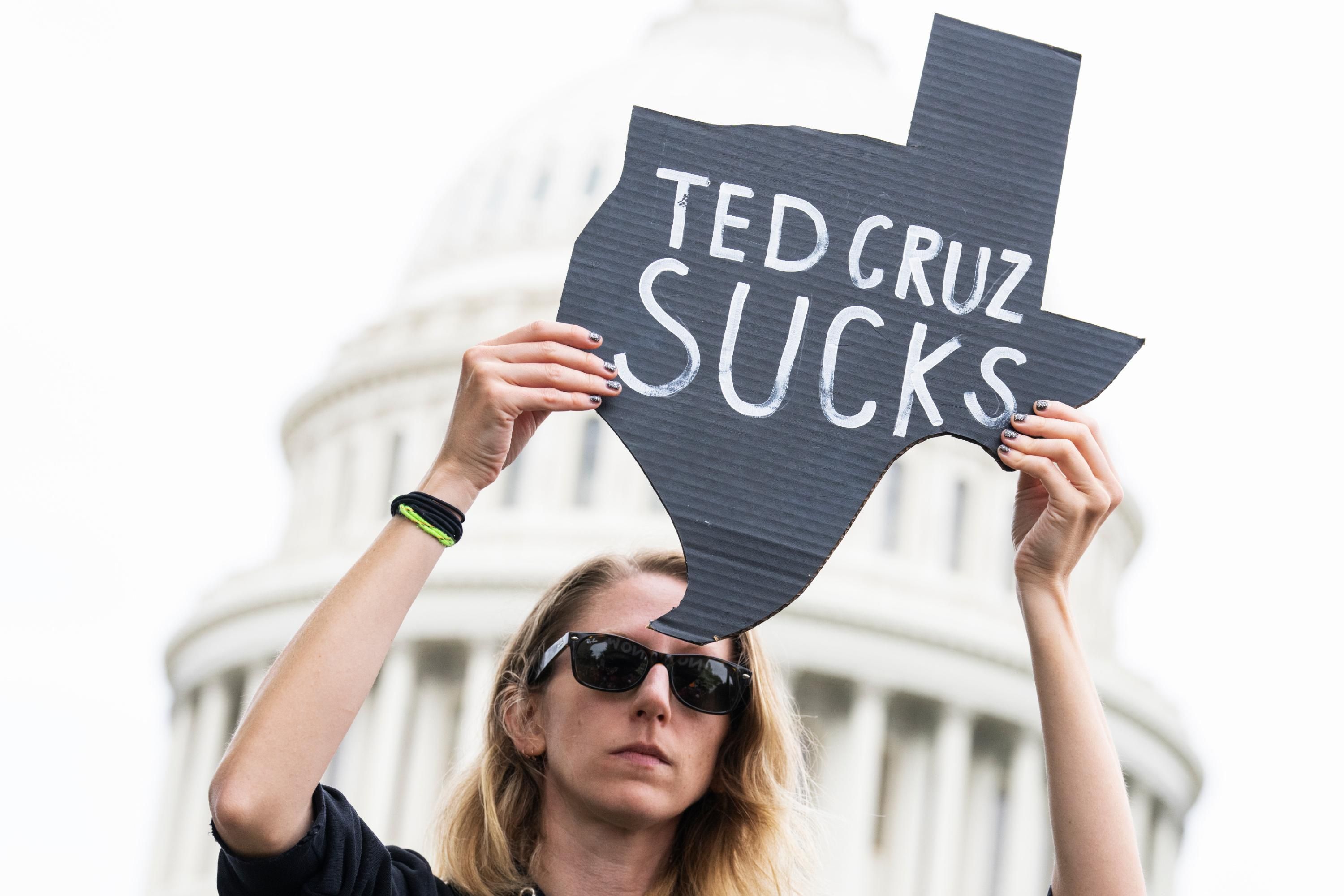 A demonstrator holds a sign condemning Republican Sen. Ted Cruz