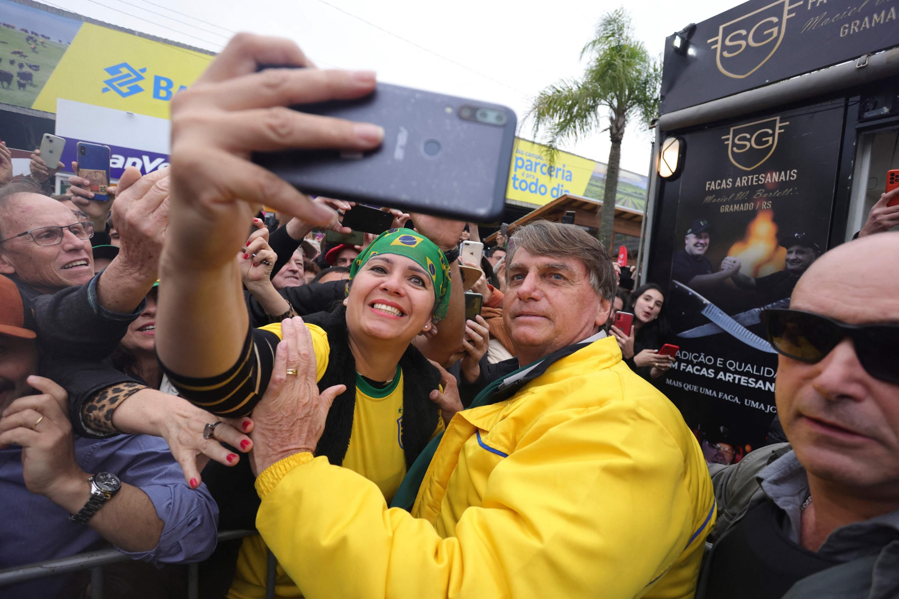 Brazilian President Jair Bolsonaro takes a selfie with a supporter