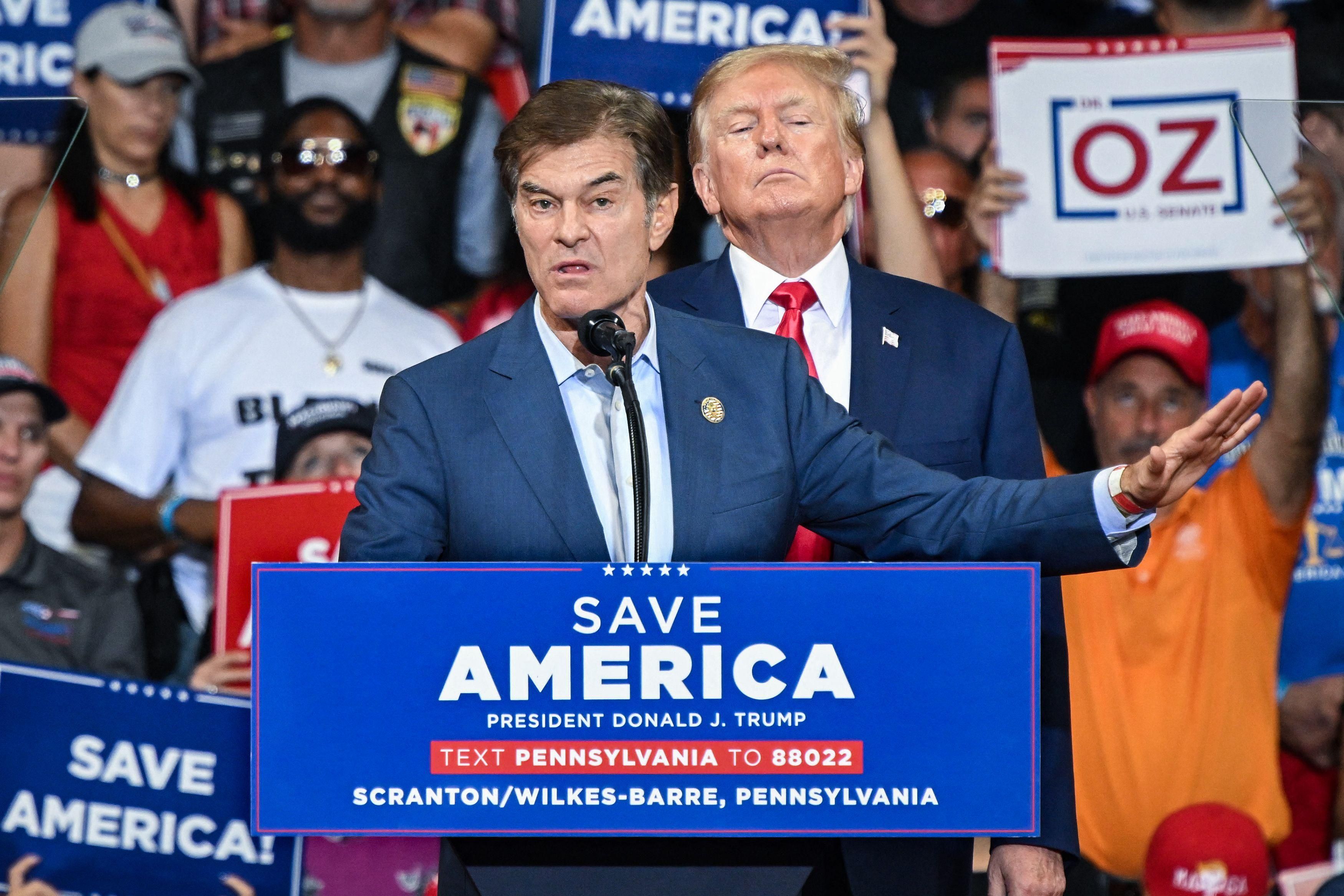 Republican U.S. Senate nominee Mehmet Oz speaks as former U.S. President Donald Trump stands behind him during a
campaign rally at Mohegan Sun Arena in Wilkes-Barre, Pennsylvania on September 3, 2022.