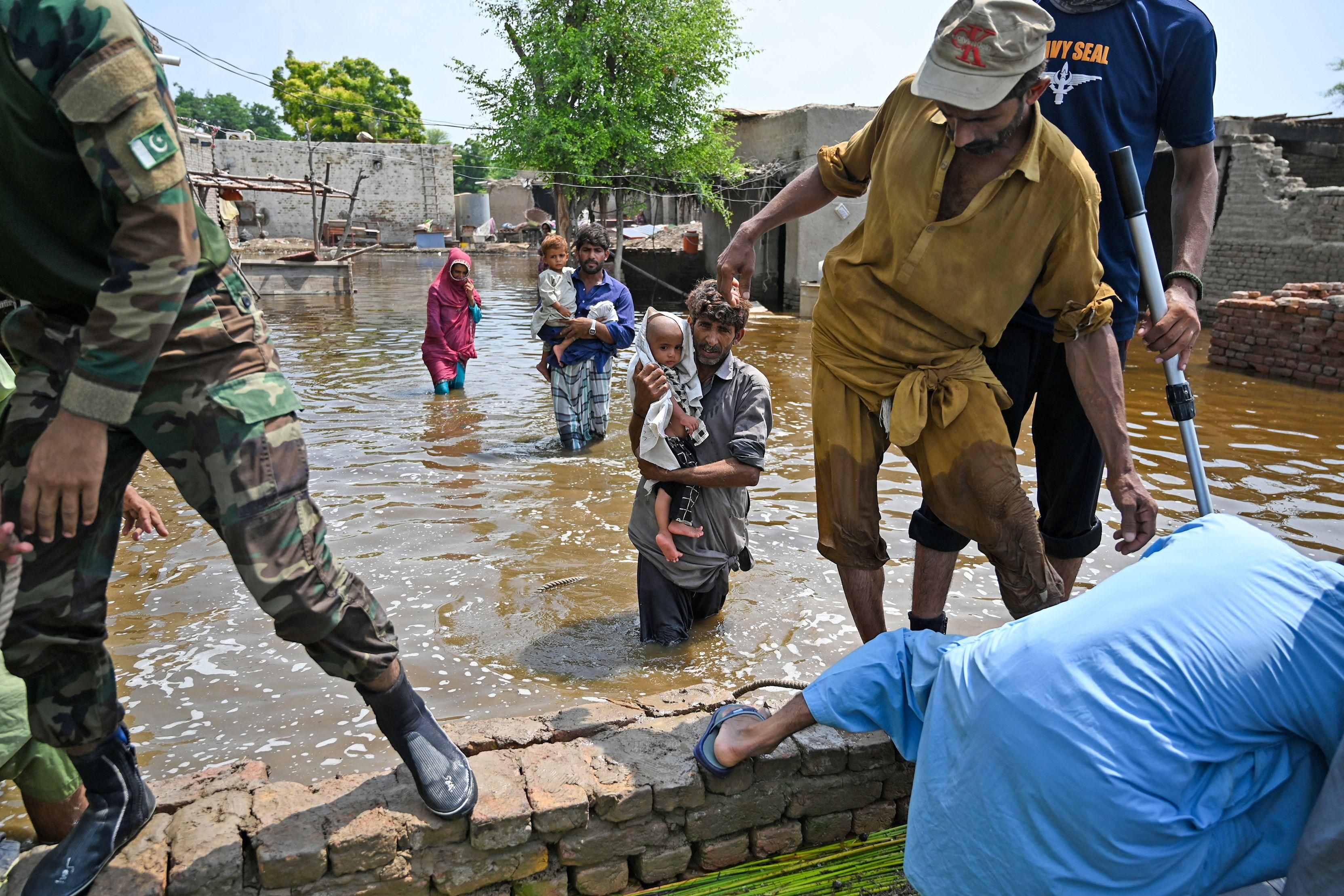 People impacted by flooding in Pakistan flee their damaged homes
