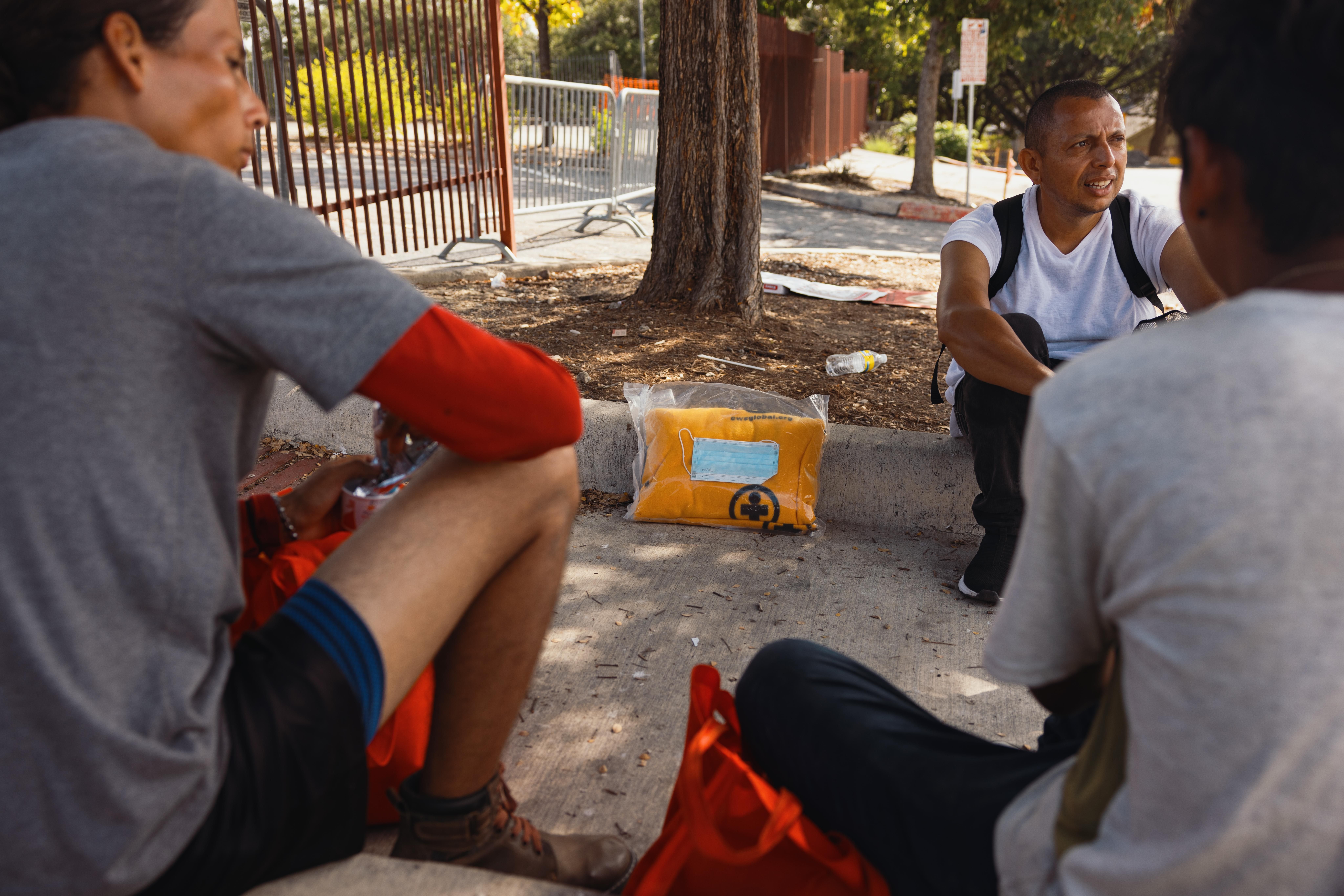 Asylum-seekers sit outside the San Antonio Migrant Resource Center on September 19, 2022. Florida Gov. Ron DeSantis has used the false promise of refugee resettlement benefits to lure immigrants onto flights from the center in Texas to Martha's Vineyard in Massachusetts.