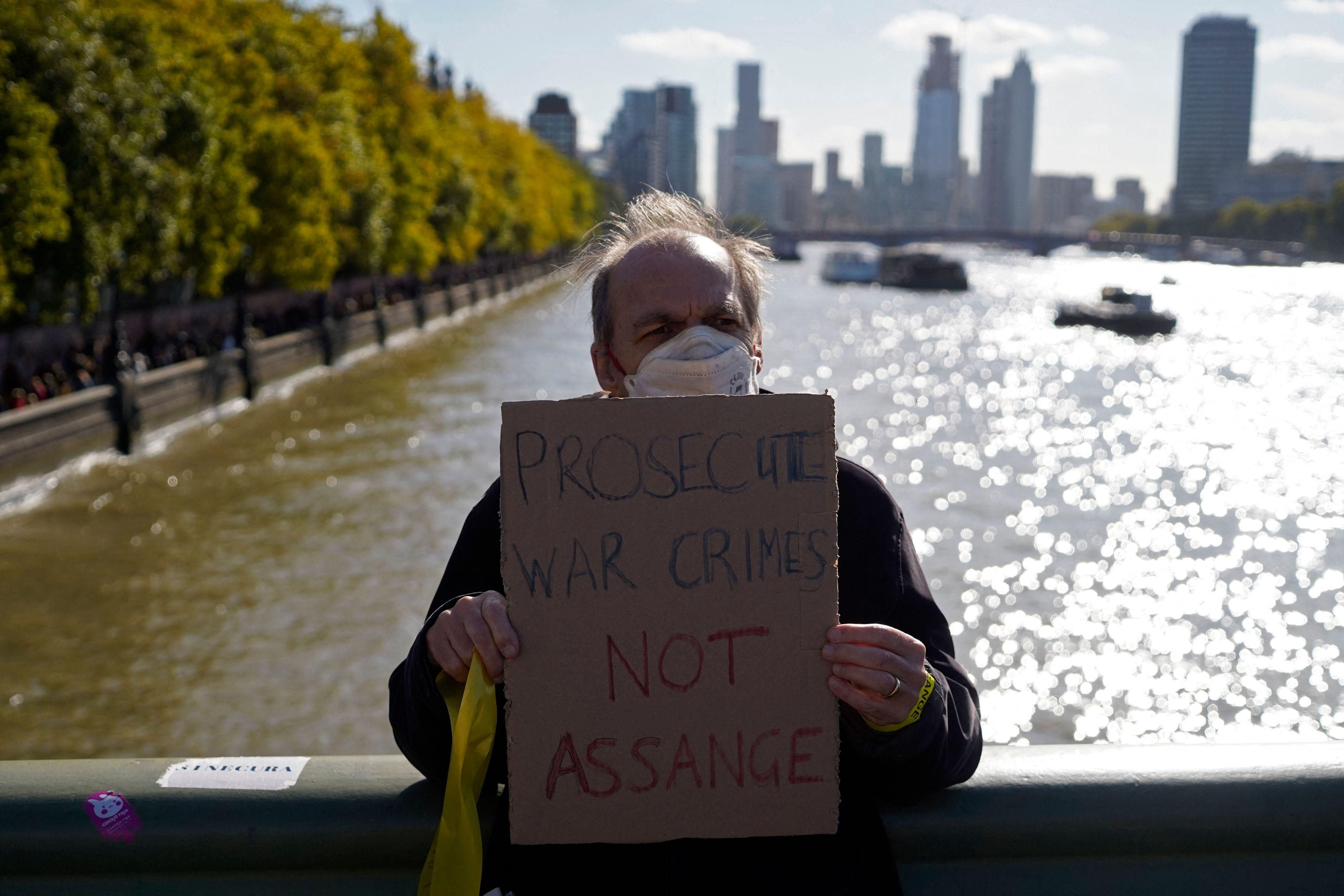 A supporter of WikiLeaks founder Julian Assange holds a placard outside the British parliament in London on October 8, 2022.