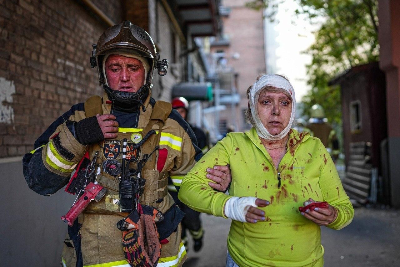 A Ukrainian emergency worker assist a woman injured by Russian airstrikes