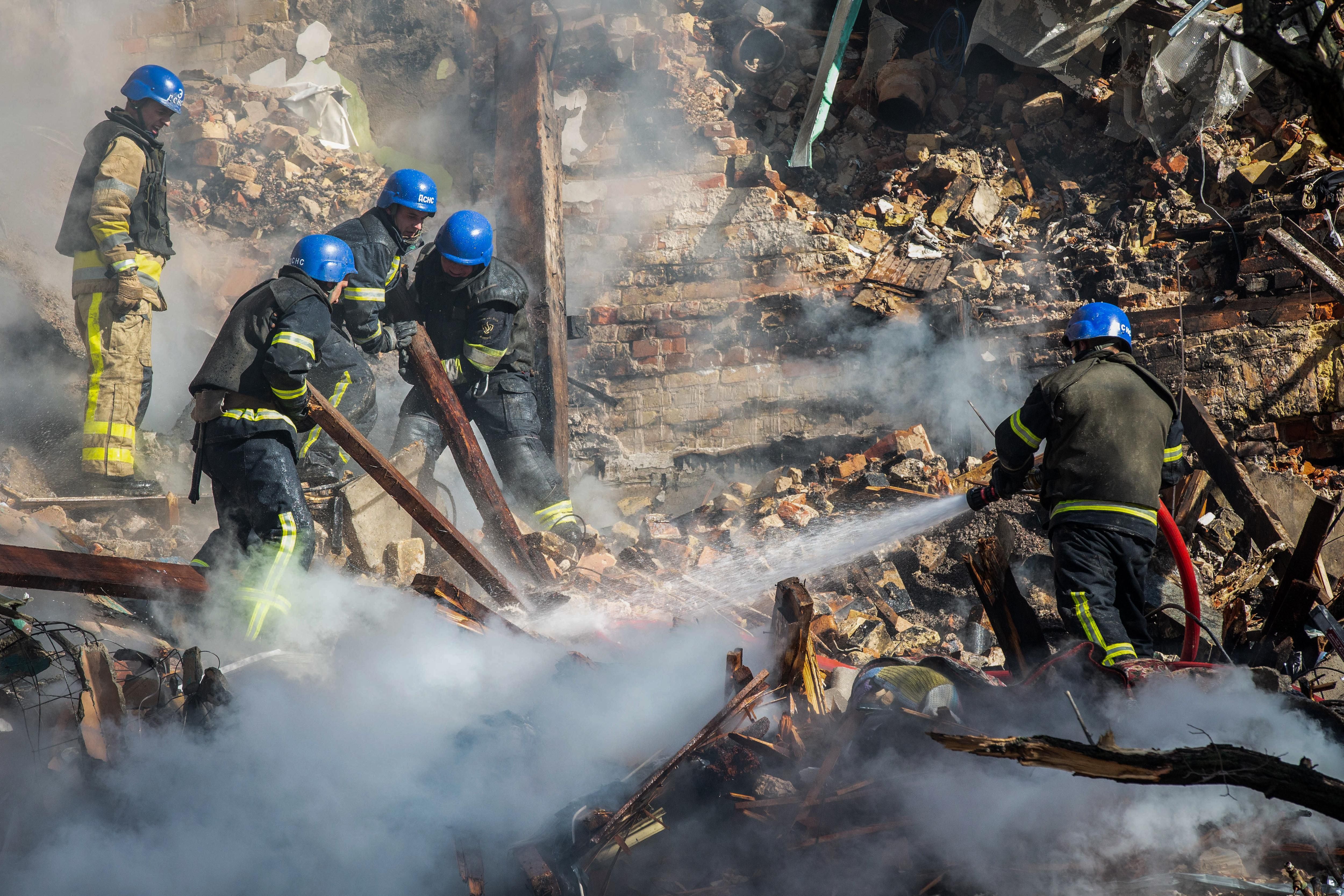 Rescue workers pour water on rubble following Russian attack on Kyiv