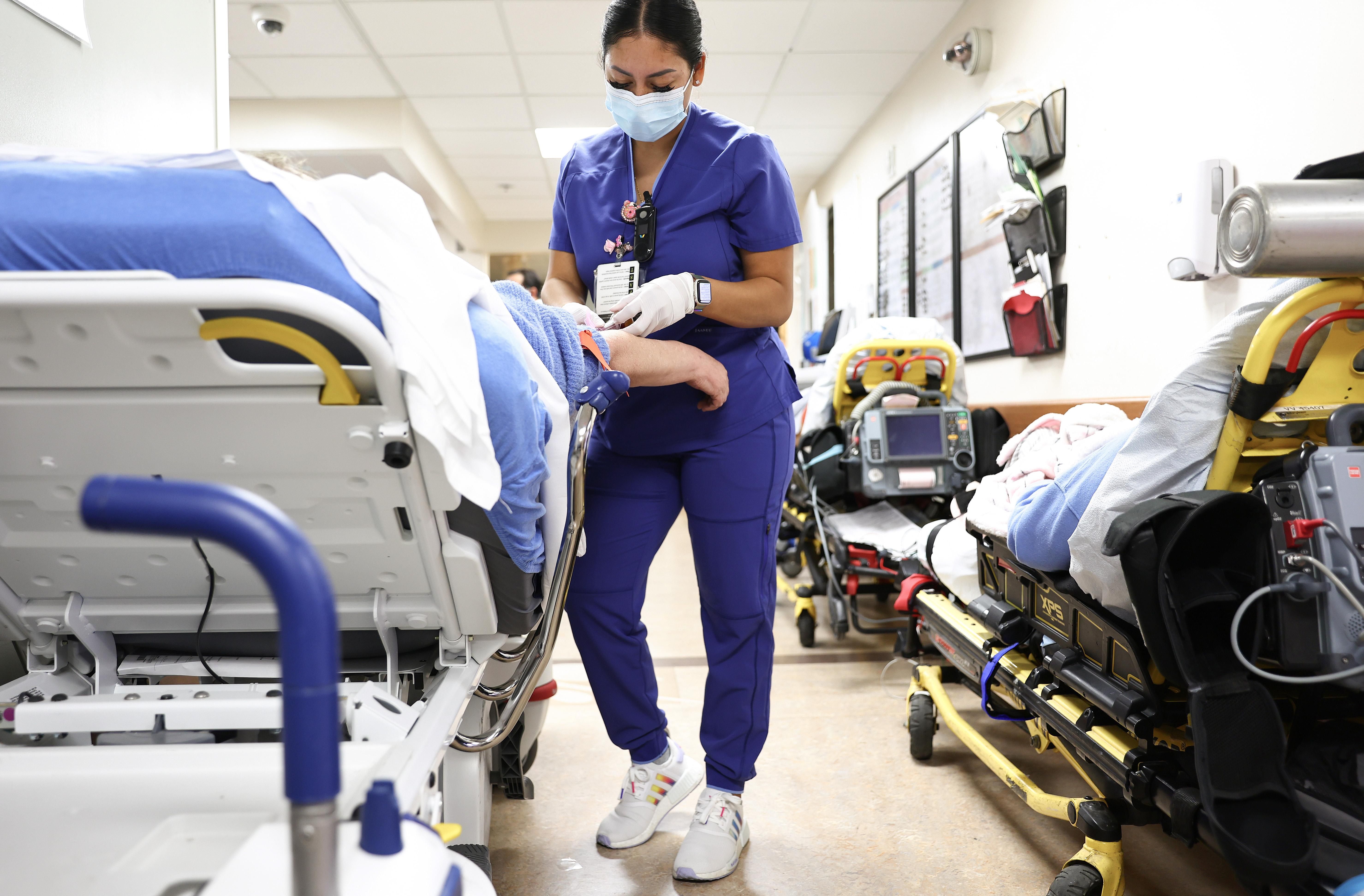 Lab technician Alejandra Sanchez cares for a patient in the emergency department at Providence St. Mary Medical Center on March 11, 2022 in Apple Valley, California.