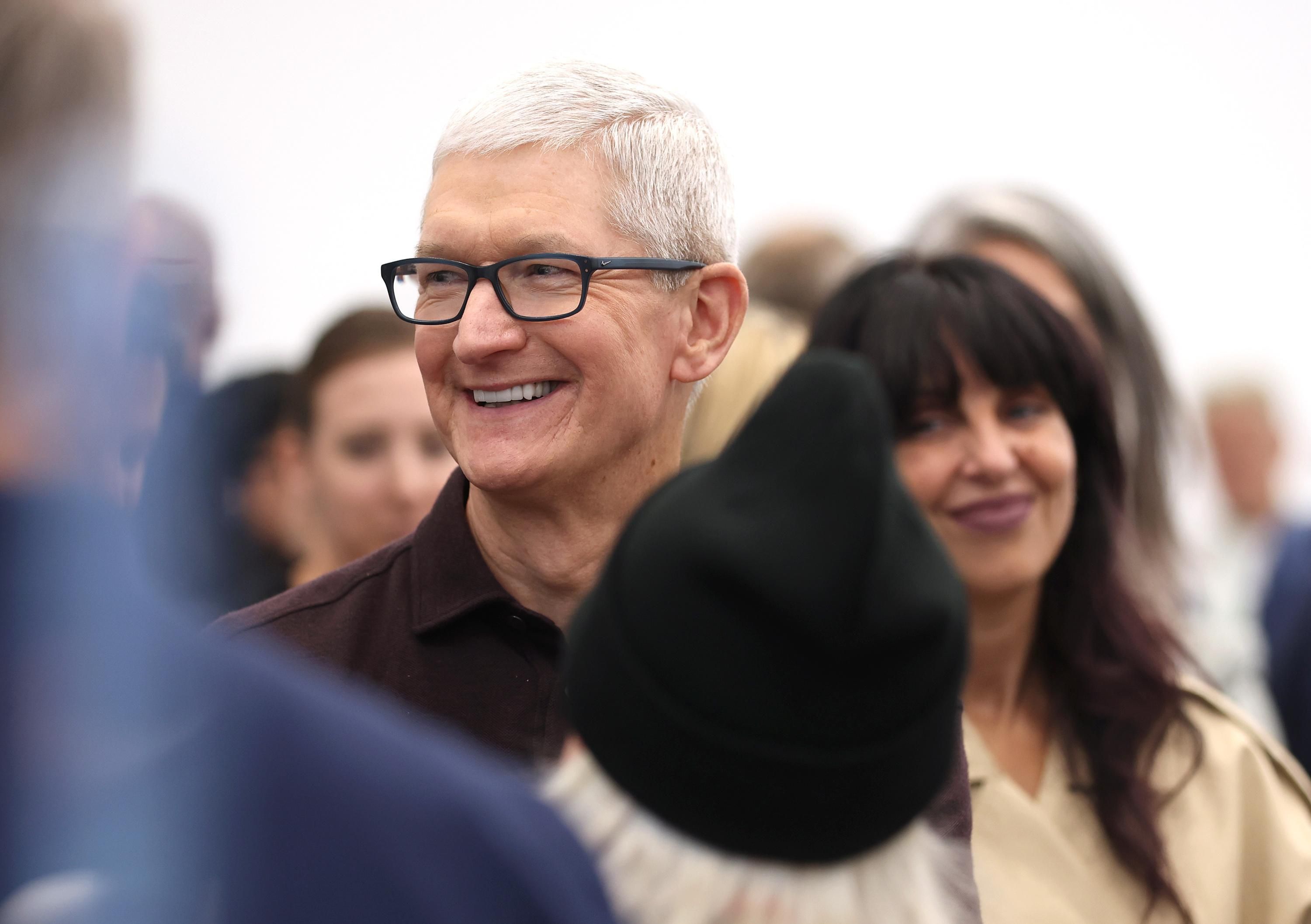 Apple CEO Tim Cook walks through a crowd during an event