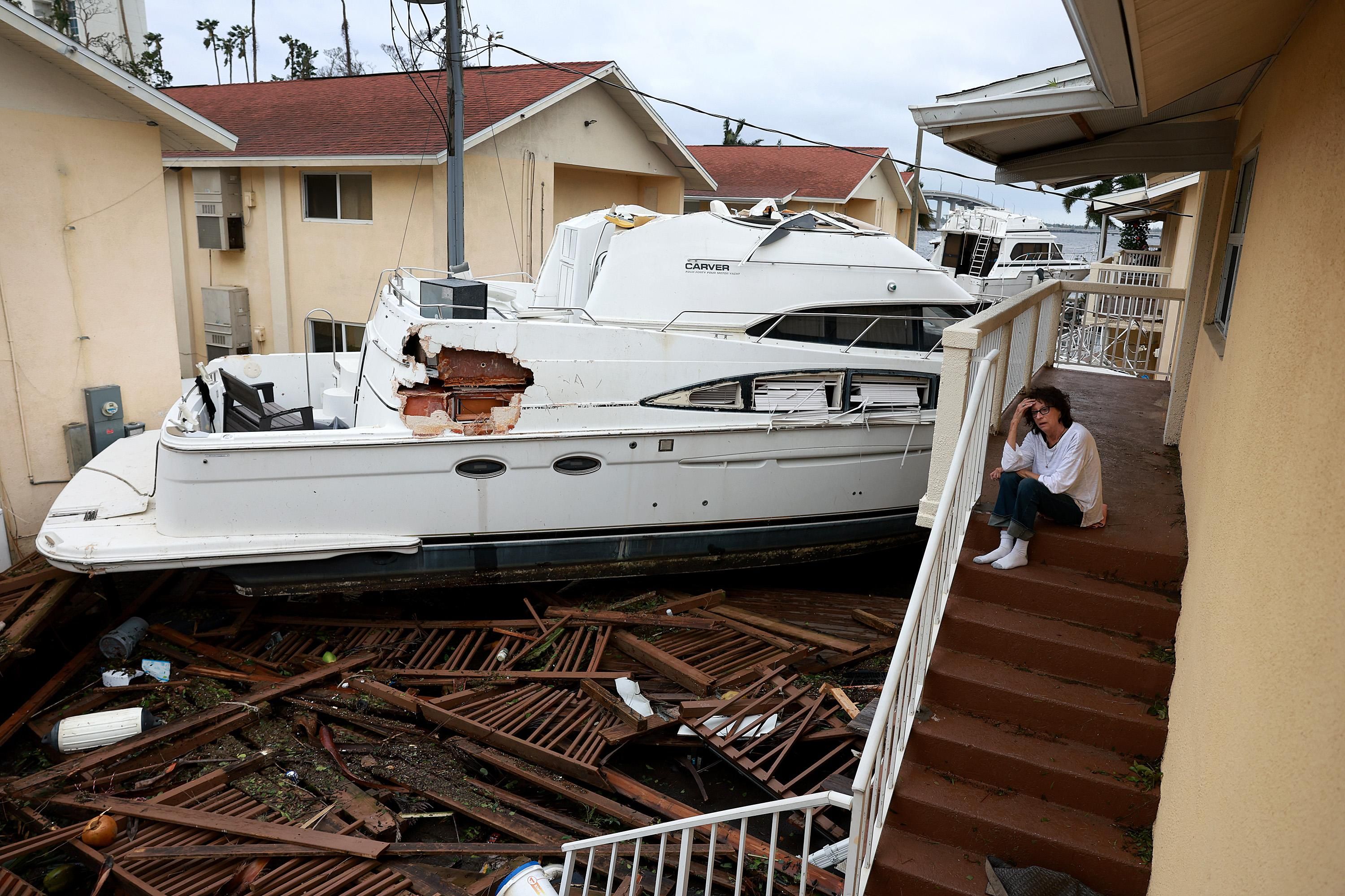 A boat resting against an apartment building after Hurricane Ian