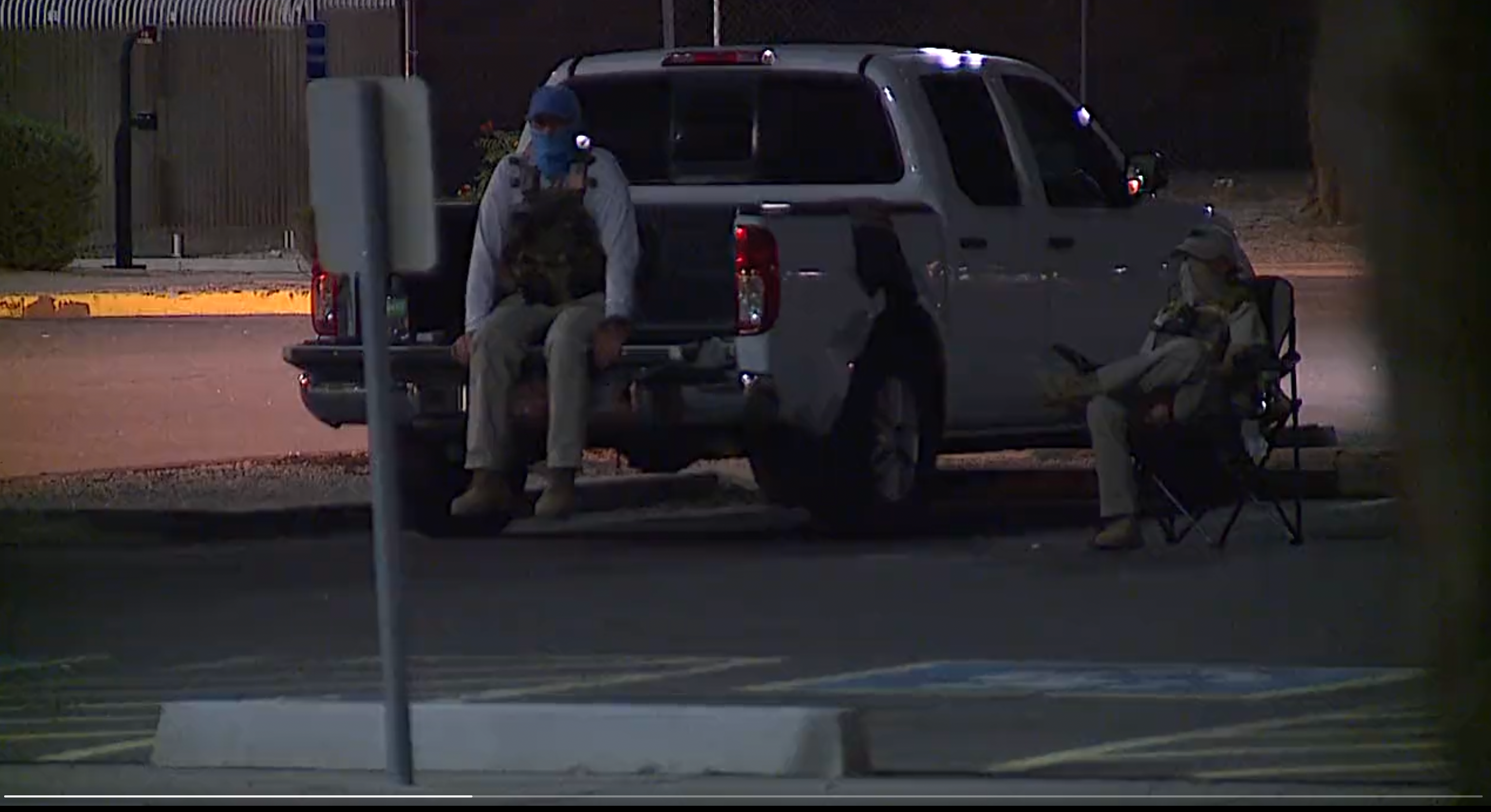 Poll watchers dressed in tactical gear watch a ballot dropbox location