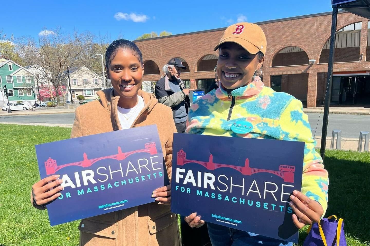 Two women holding signs that say "Fair Share for Massachusetts"