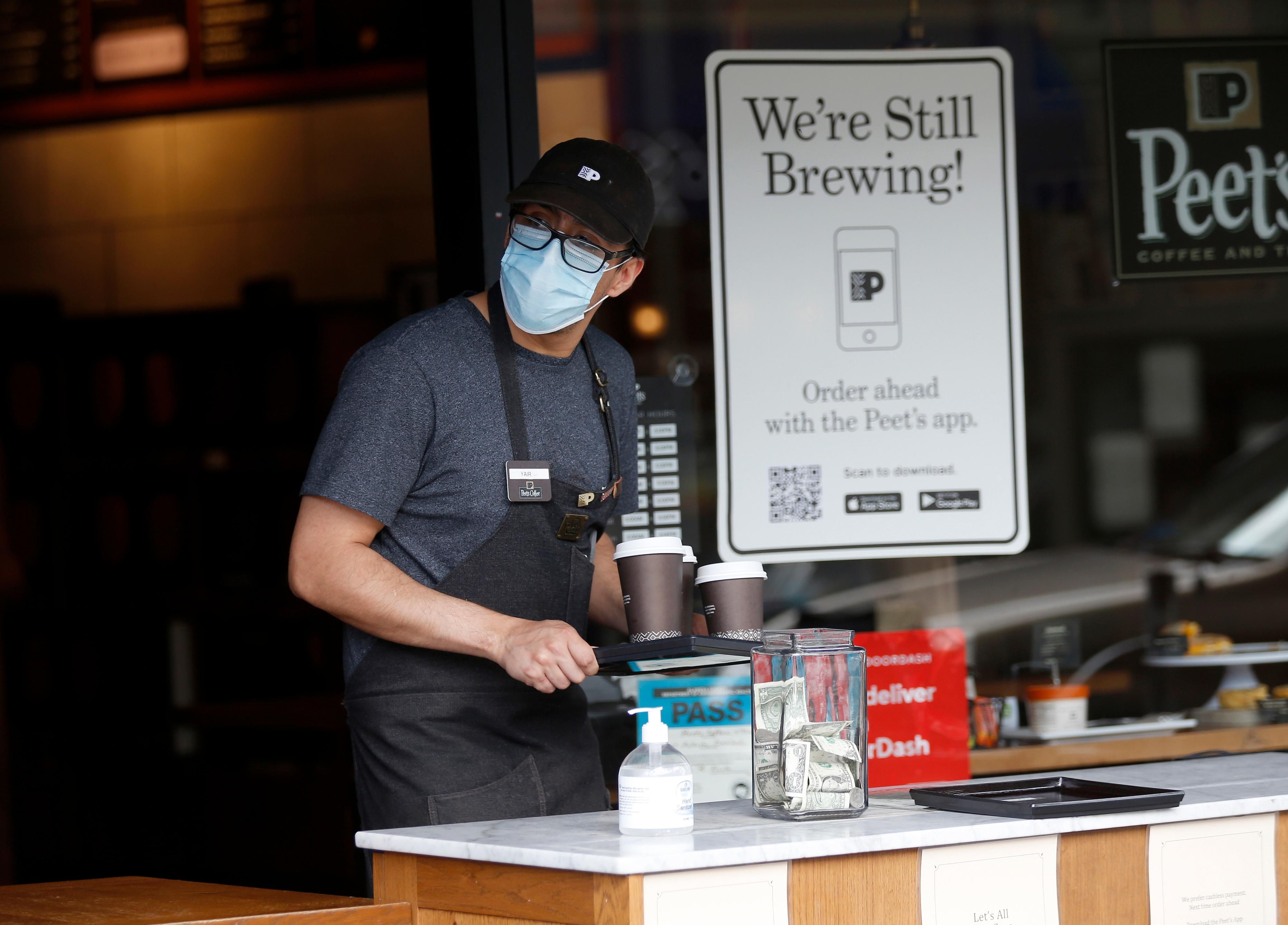 A Peet's coffee worker prepares a takeout order