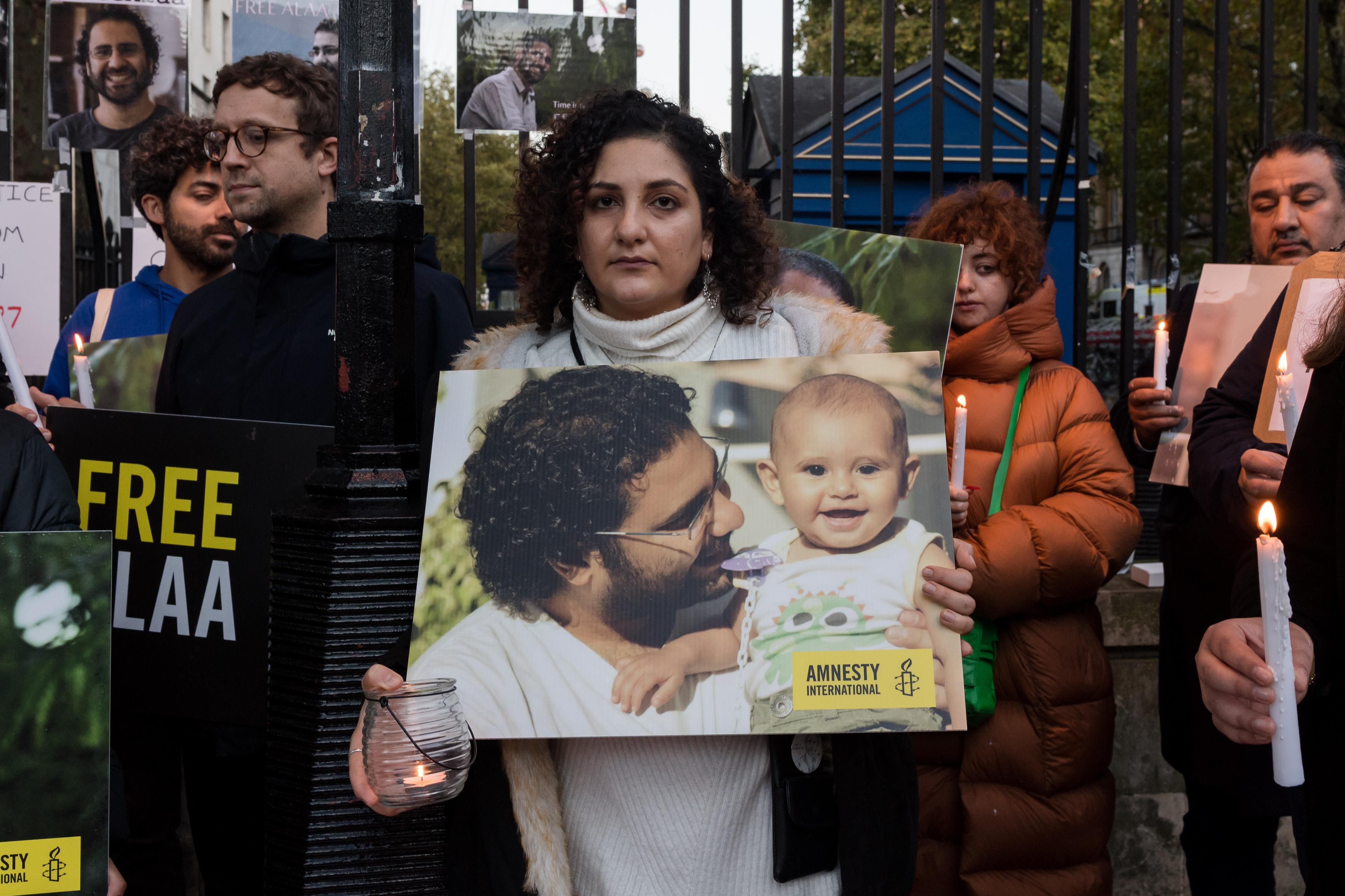 Mona Seif (C), sister of the jailed British-Egyptian human rights activist Alaa Abd el-Fattah, is joined by supporters during a vigil outside Downing Street to demonstrate concern for her brother