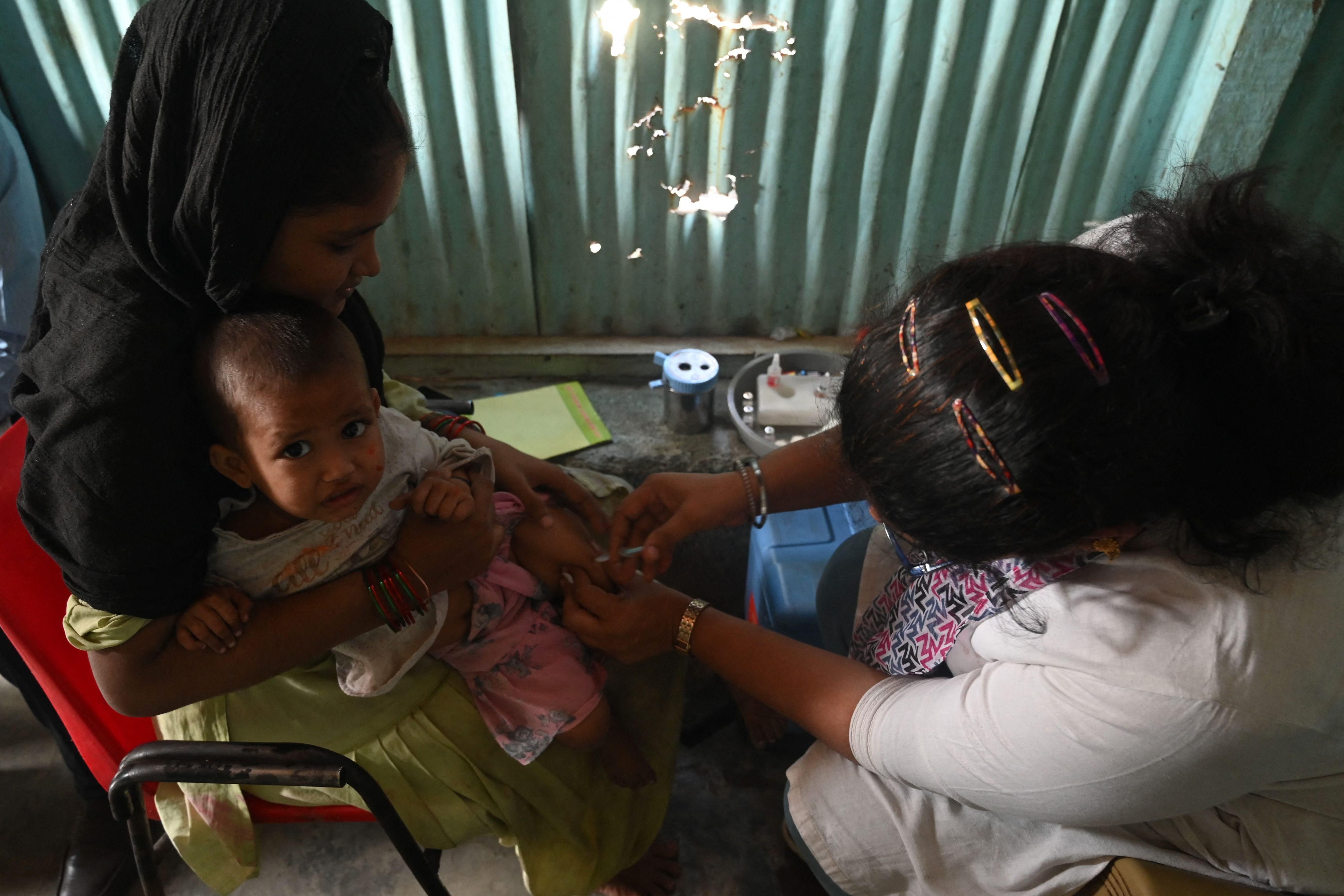 A health worker administers a vaccine to a child following a measles outbreak that killed at least 10 children in Mumbai on November 23, 2022.