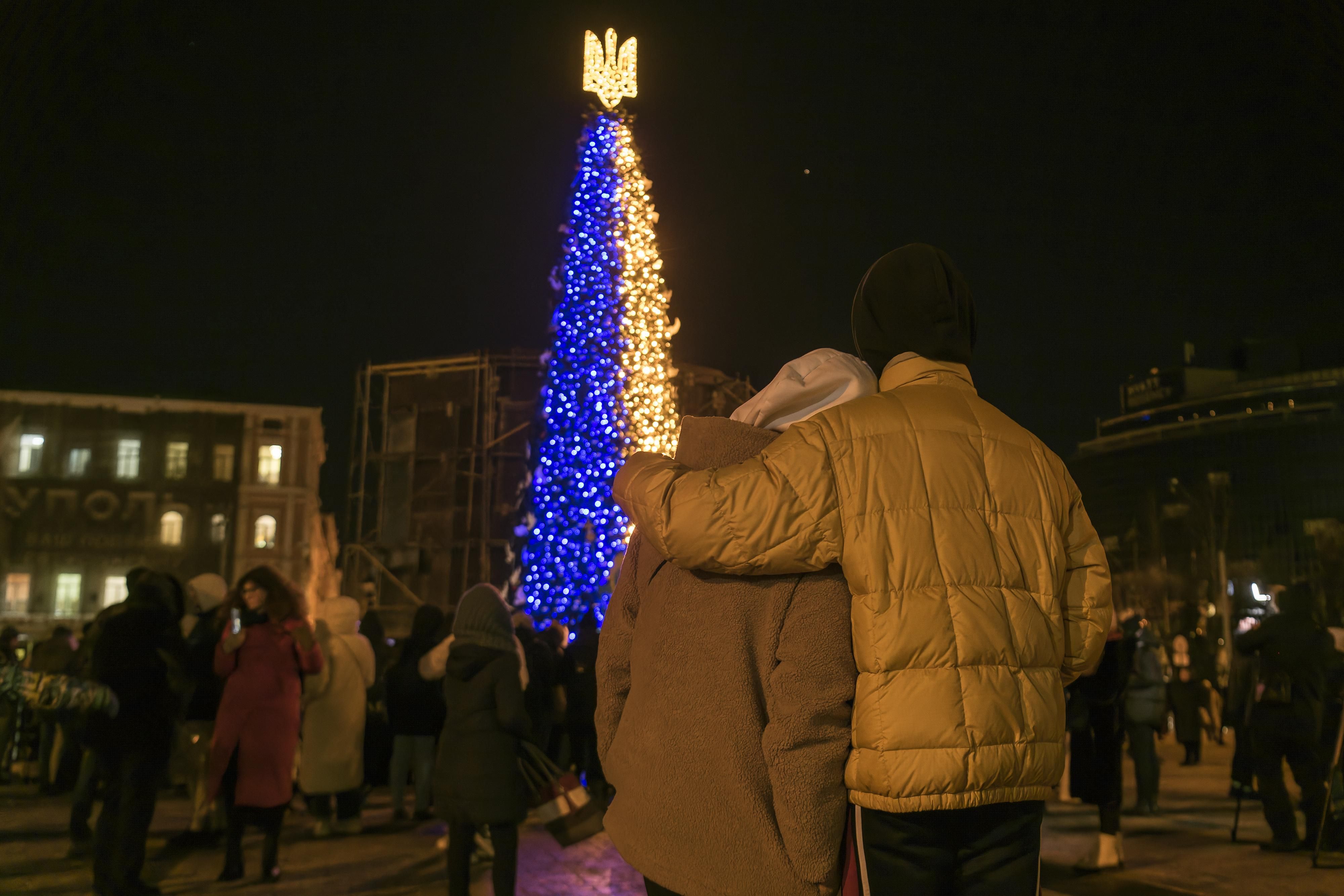 Ukrainians take photos near a Christmas tree in kyiv.