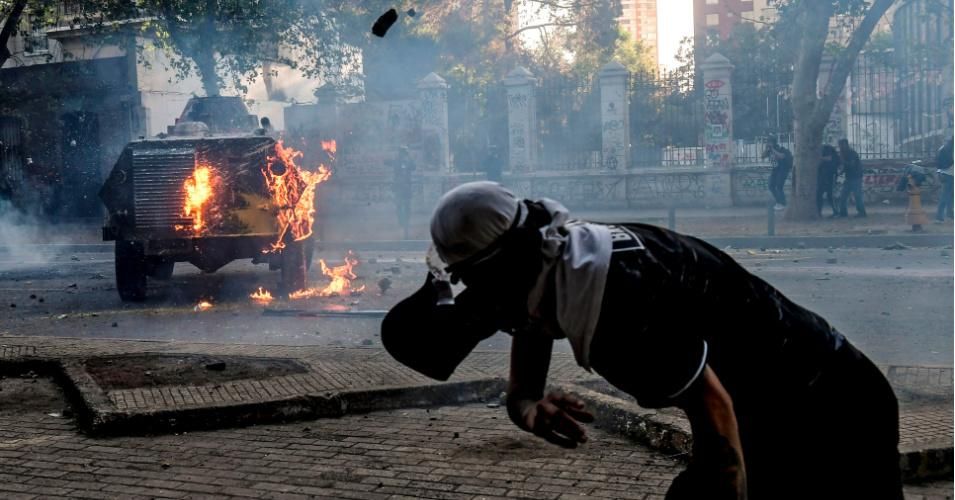 A demonstrator throws stones at a police vehicle during a protest against extreme economic inequality in Santiago, Chile on November 29, 2019. (Photo: Martin Bernetti/AFP via Getty Images)