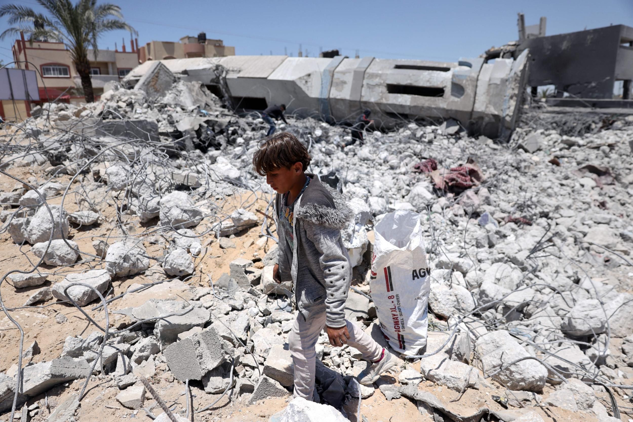A Palestinian child collects debris from the rubble of a destroyed mosque in Beit Lahia, in the northern Gaza Strip, on May 27, 2021. (Photo: Thomas Coex/AFP via Getty Images)